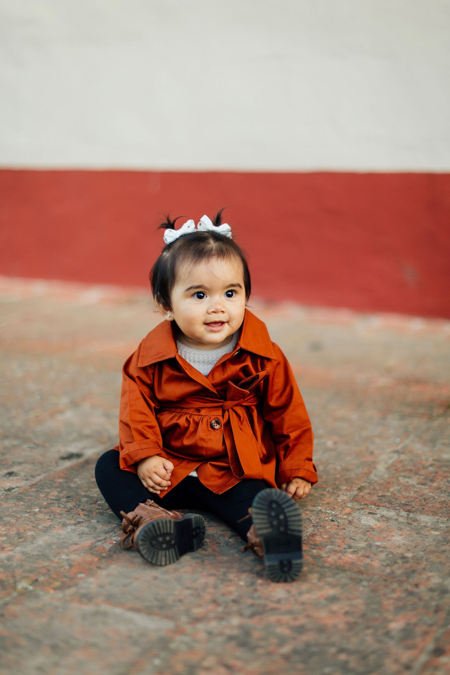 A side-by-side sequence of photos shows a small child in an orange jacket exploring a textured surface outdoors.