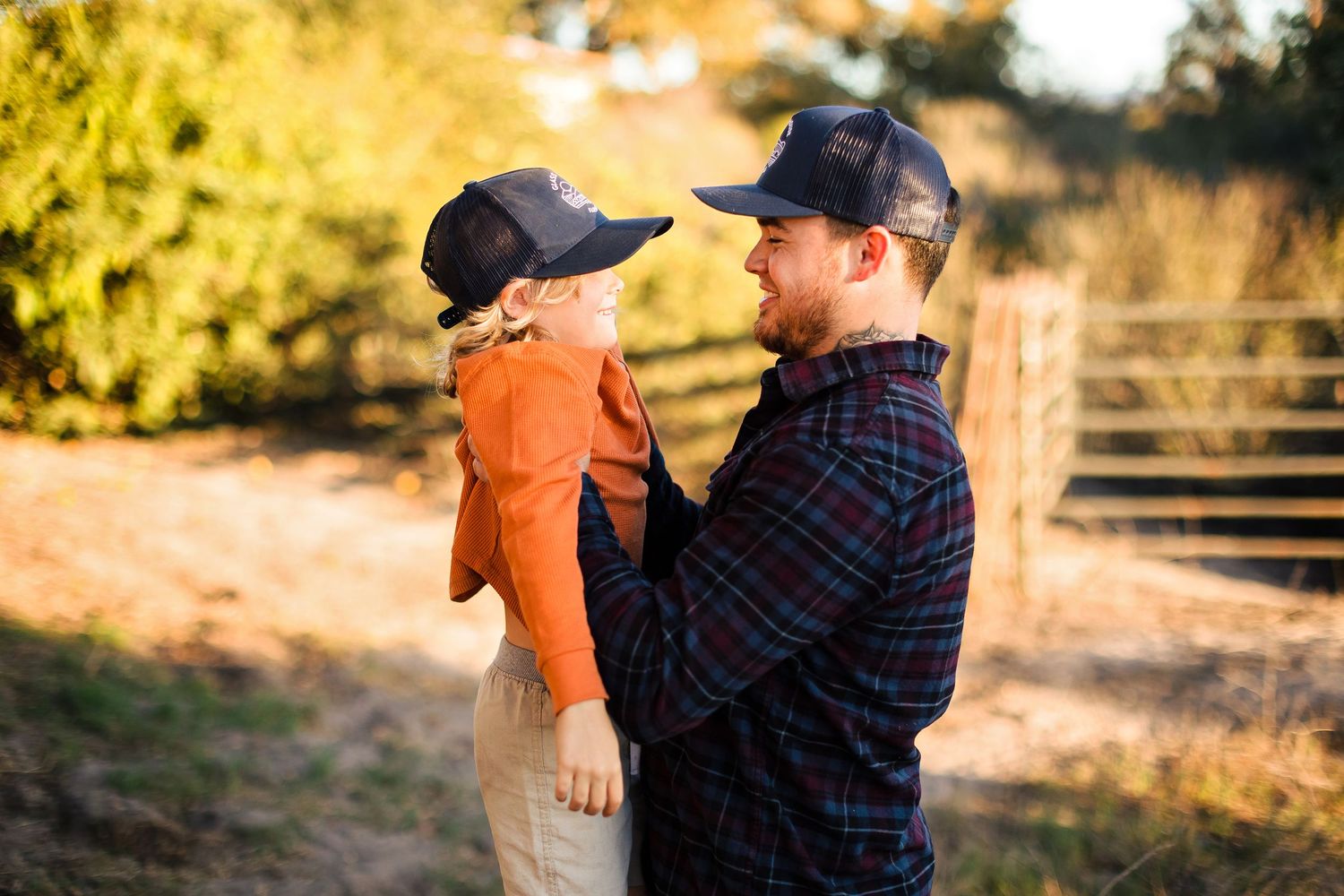 Family plays together in backyard during golden sunset hour while wearing casual clothes.