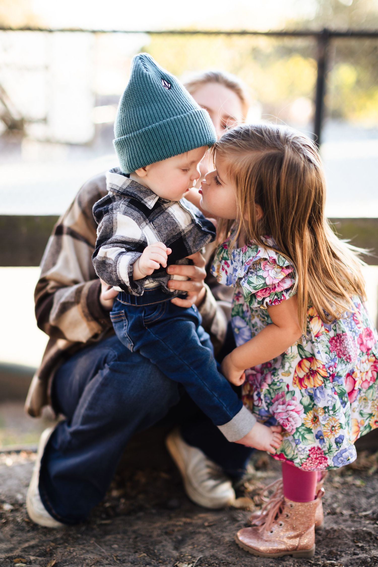 Two children share tender moments while playing outdoors in a series of sweet candid photos.