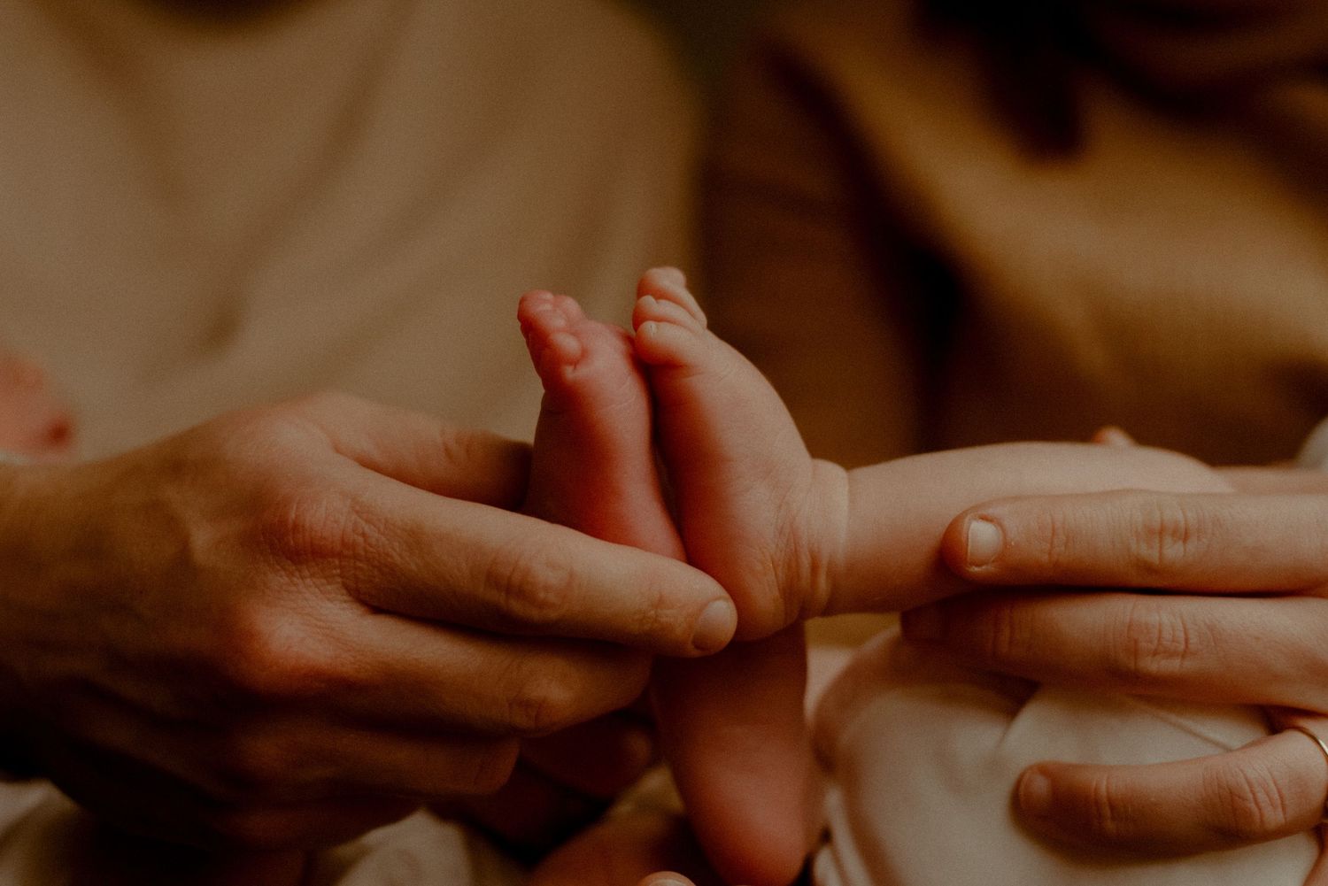 Close-up of hands performing a traditional massage therapy treatment on bare skin in warm lighting.