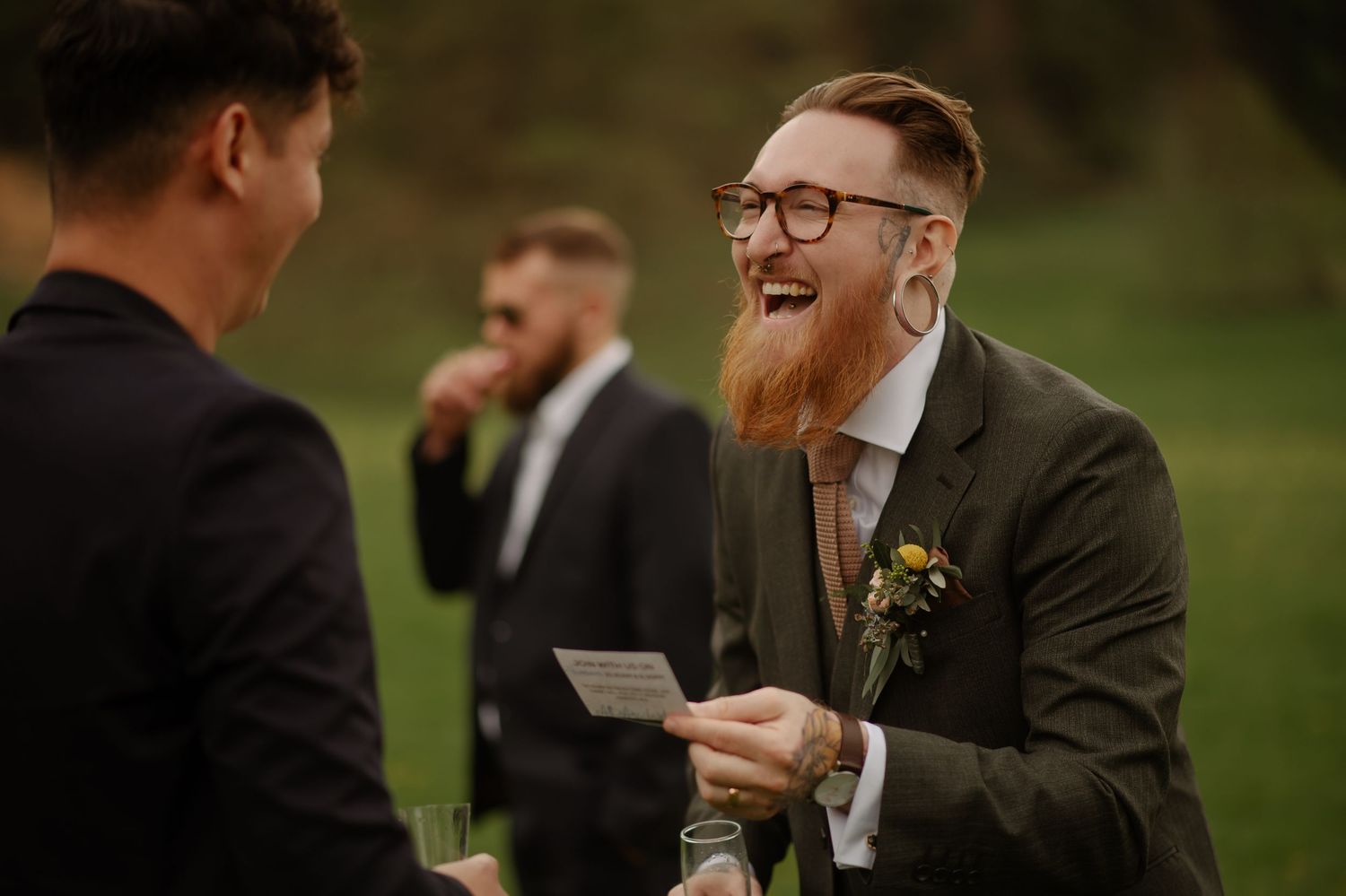 A group of wedding guests sharing laughter and conversation during an outdoor celebration.