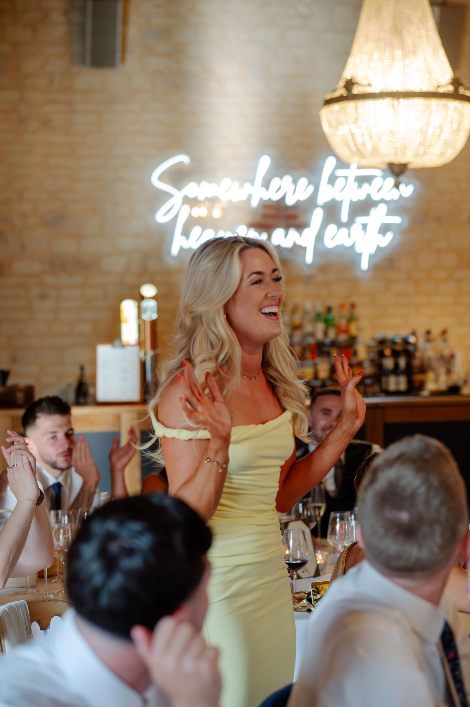 A series of candid reception photos showing guests in yellow attire laughing and celebrating at a wedding dinner.