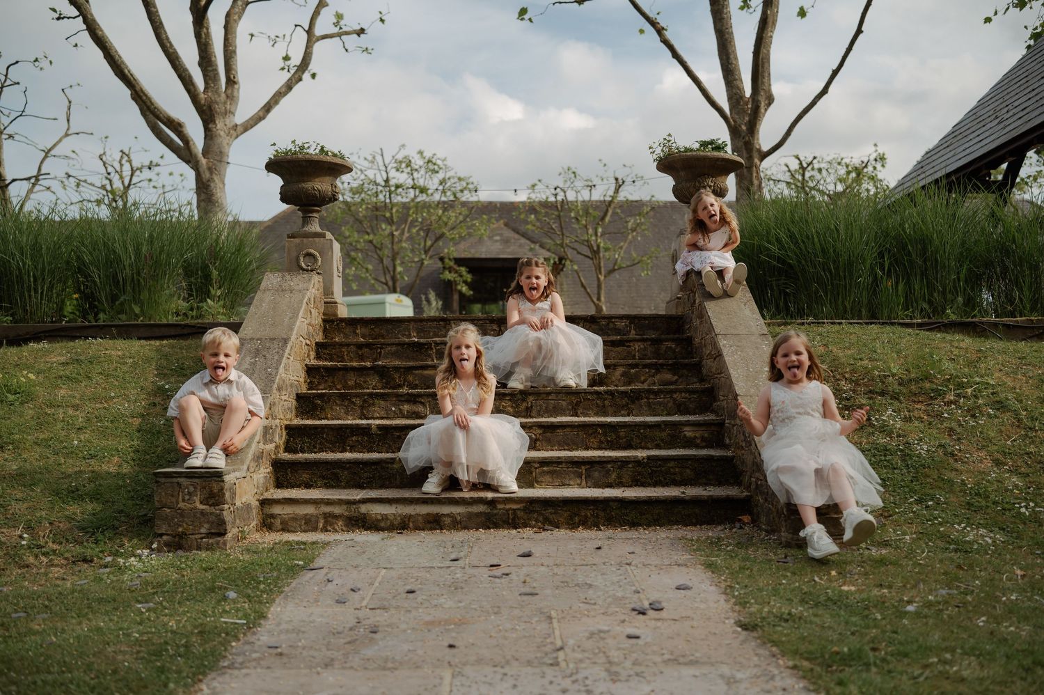 Wedding party members sitting casually on outdoor stone steps.