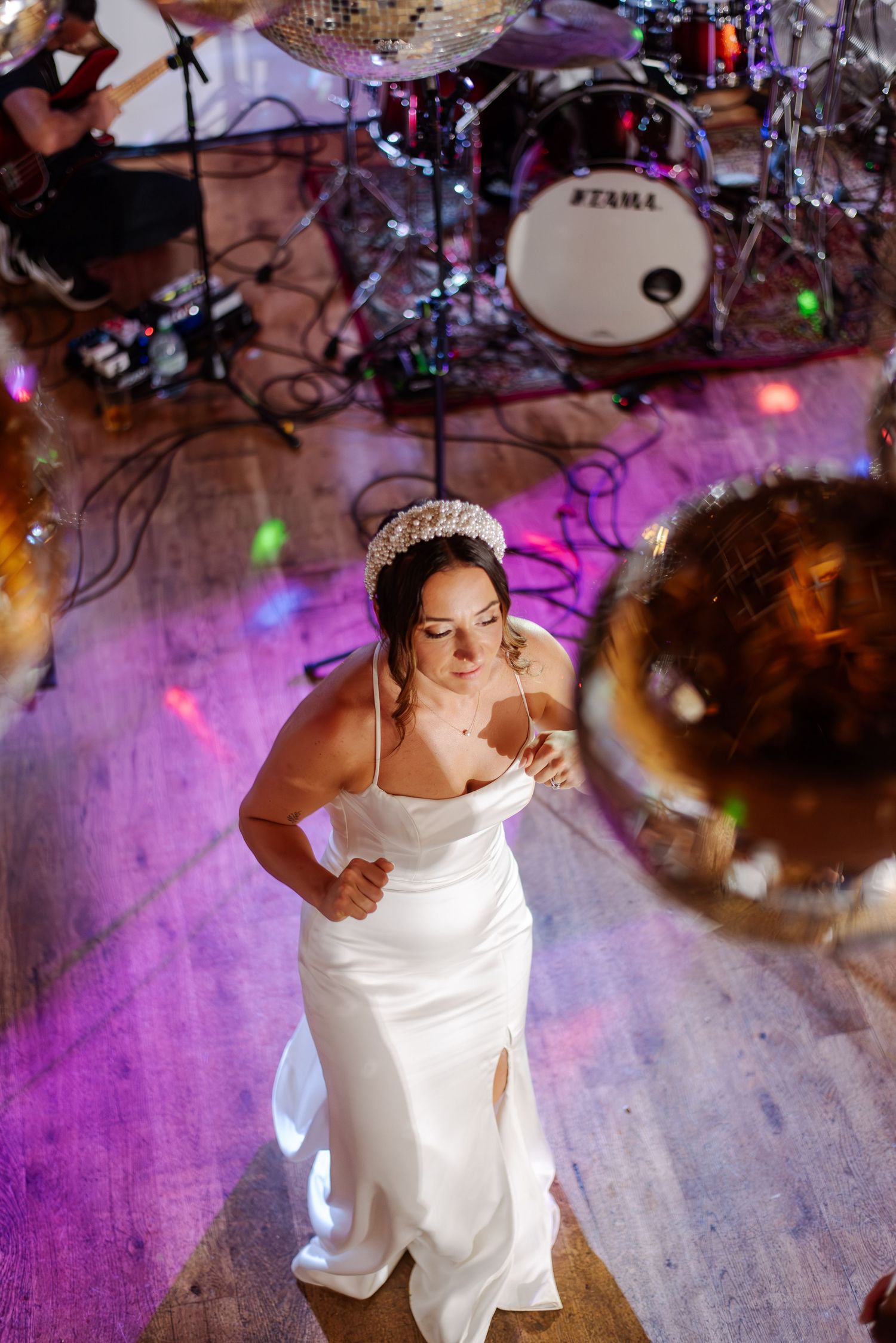 Dancing under purple lights and disco balls at wedding reception party.