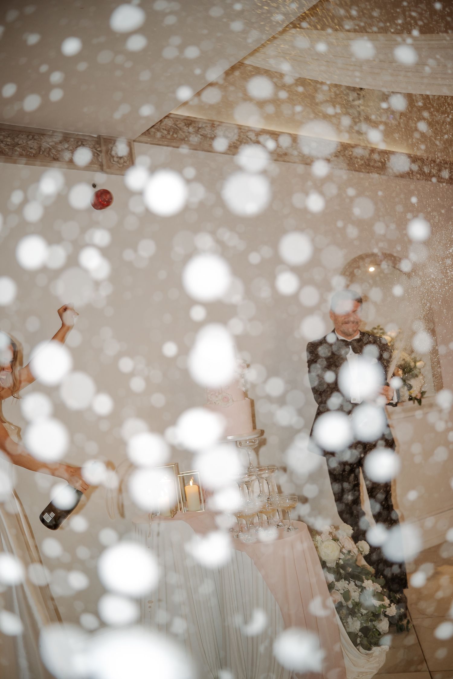 A couple shares a romantic moment at their wedding reception, surrounded by beautiful bokeh snowflake effects.
