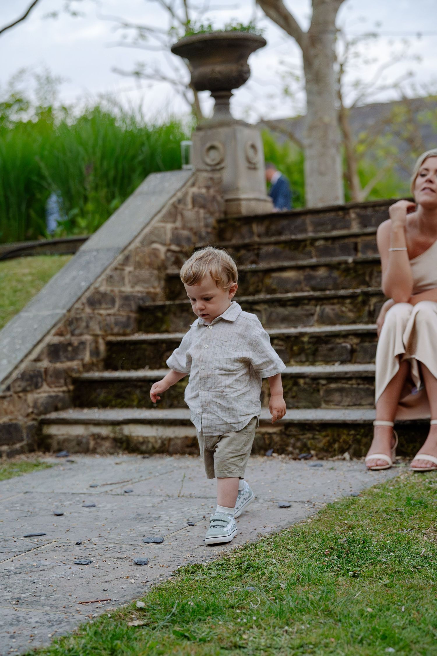 A small child walking on stone steps outdoors near a historic building.