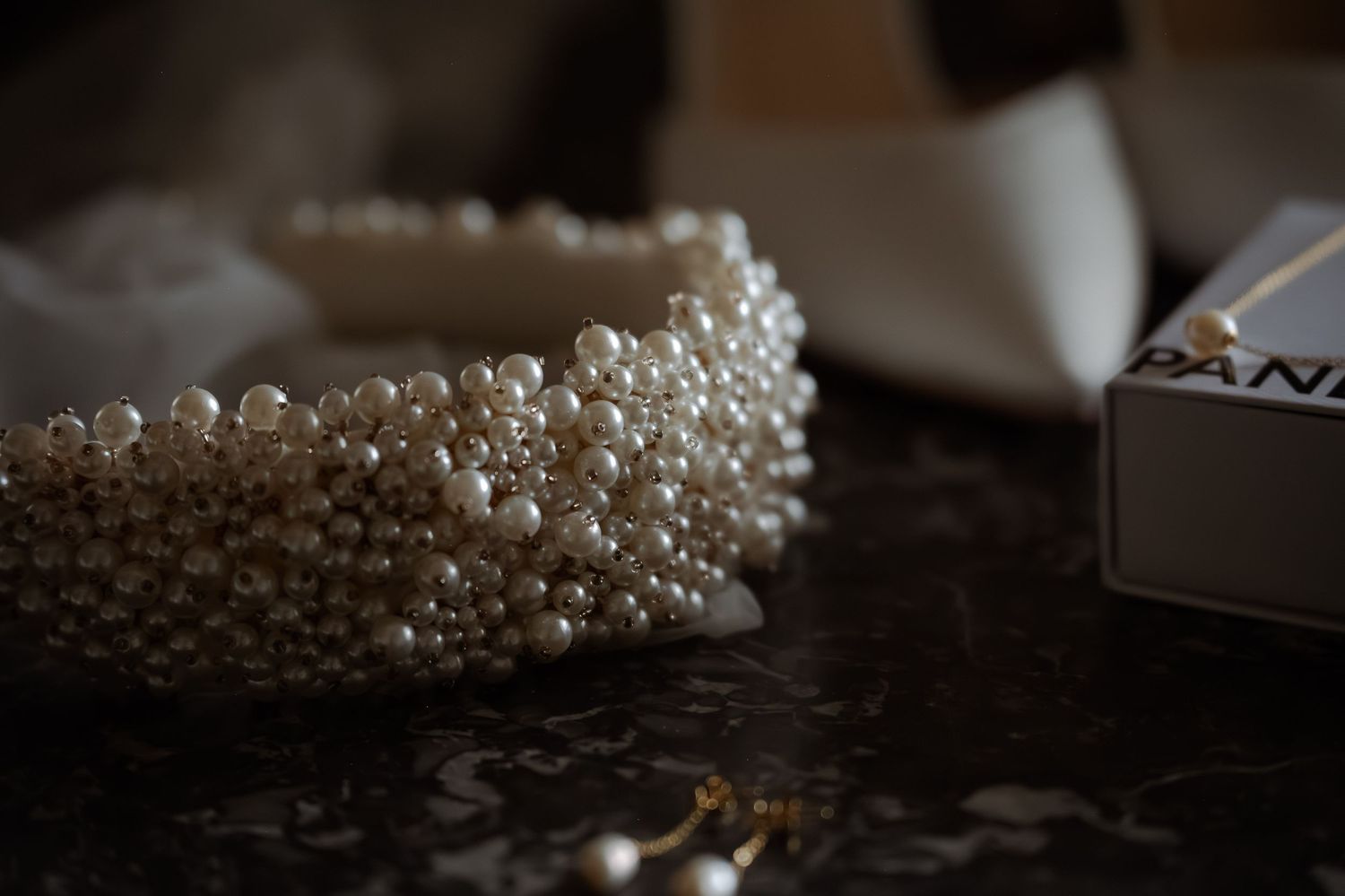Pearl beaded accessories arranged artistically in dramatic lighting.