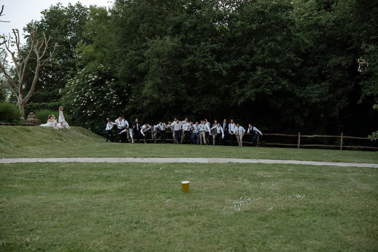 A group of people gather on a grassy lawn for an outdoor event at a park.