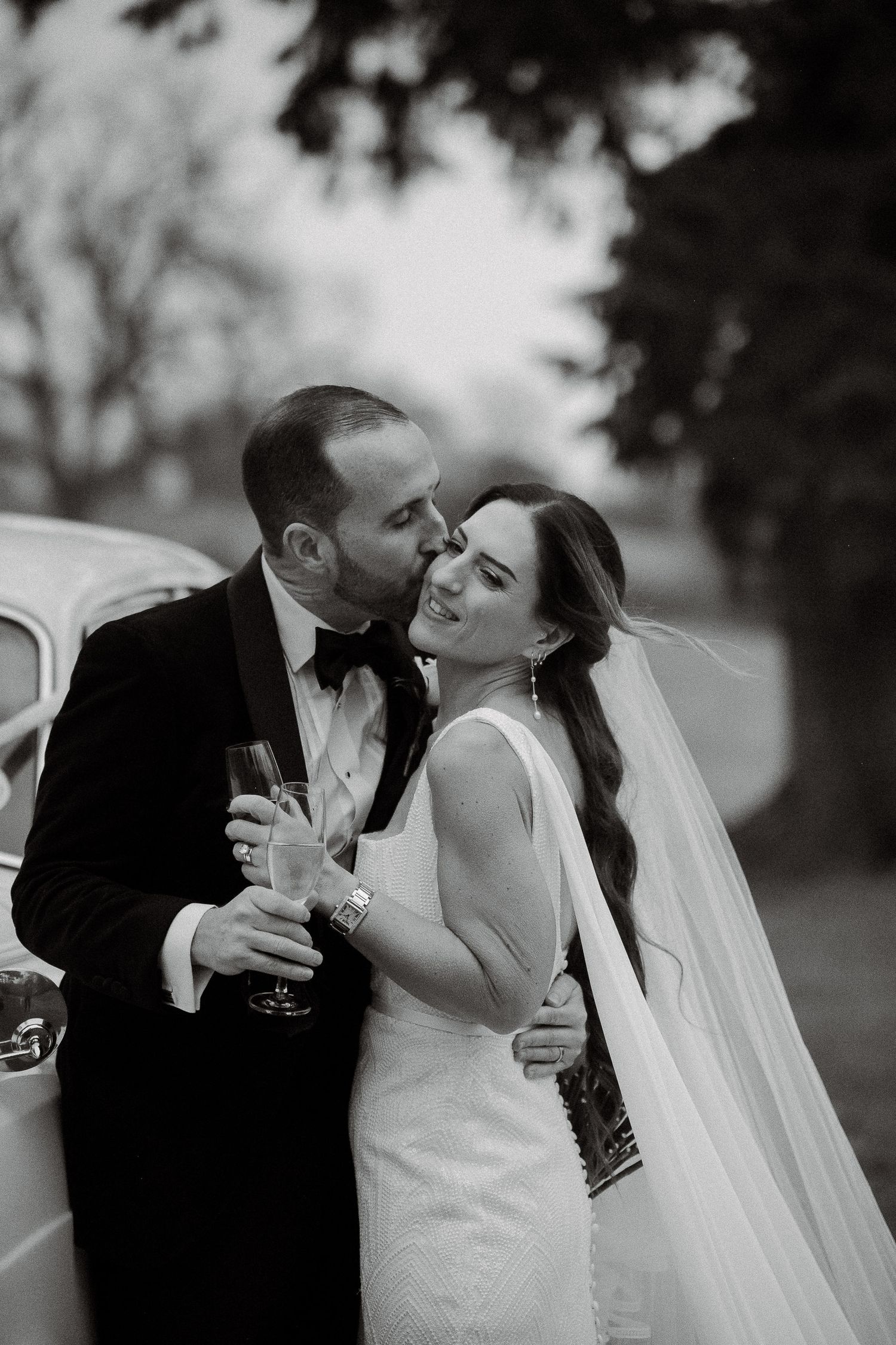 A romantic black and white wedding photo sequence showing a couple sharing champagne and kisses.