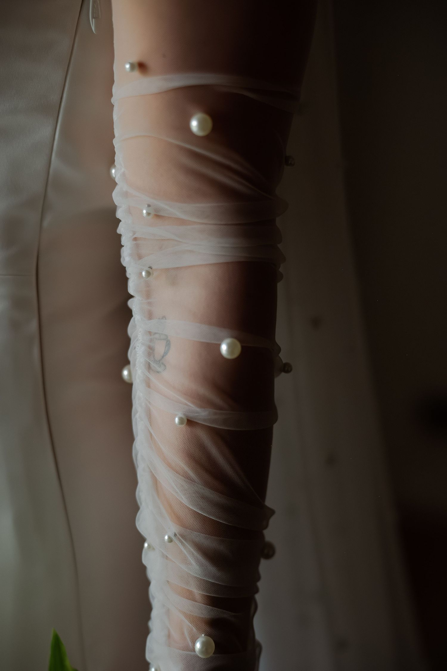 Close-up detail of delicate white pearl buttons on sheer wedding dress fabric.