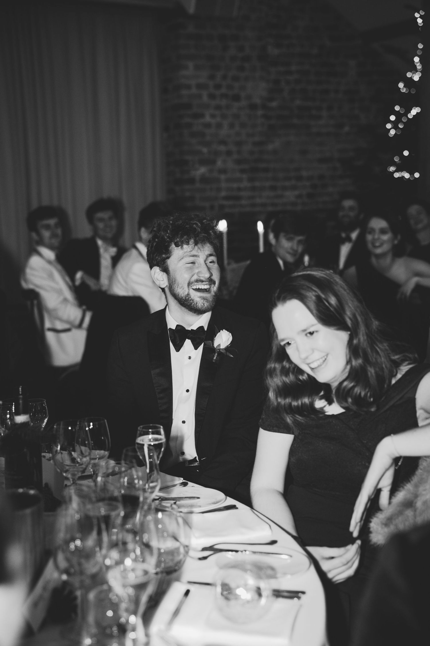 Black and white photograph of people seated at a formal dinner event wearing evening attire.