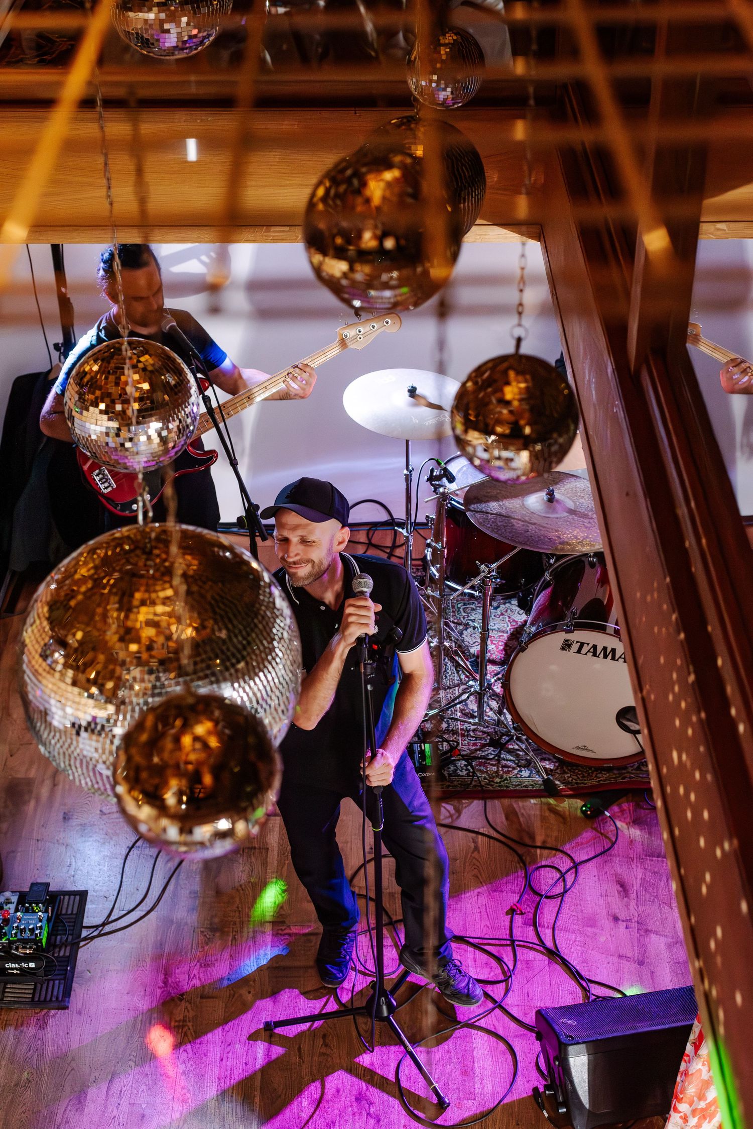 Disco balls and purple lighting create an atmospheric dance floor setup at a wedding reception.