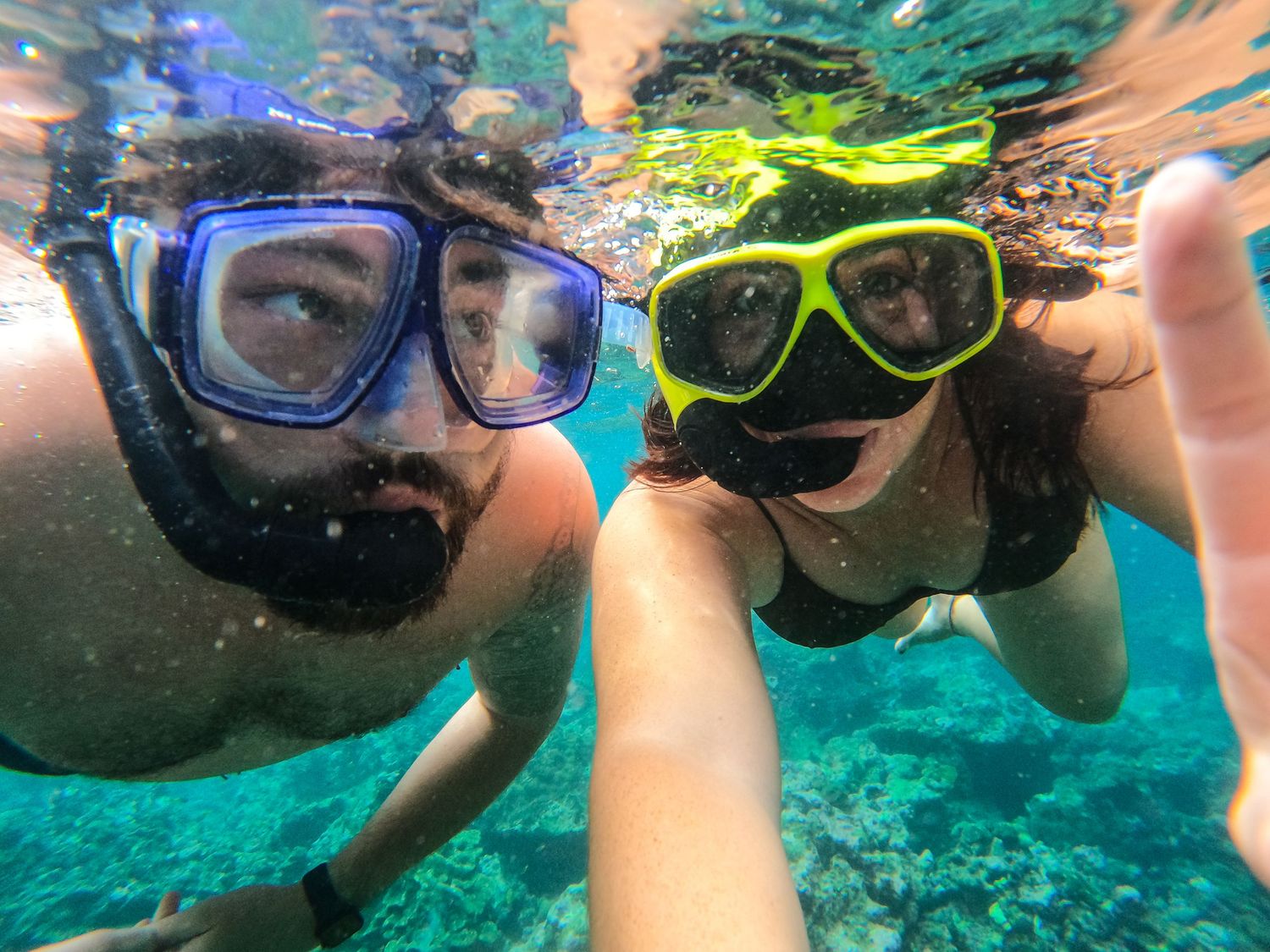 A series of underwater selfie shots showing snorkelers exploring clear turquoise waters with colorful masks and goggles.