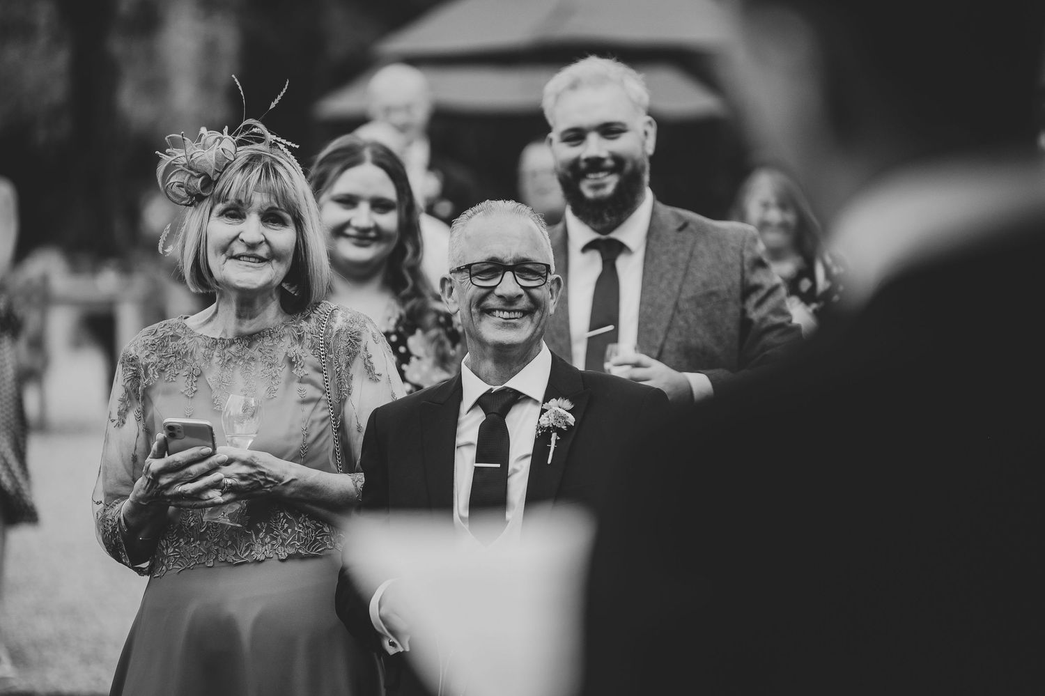Black and white wedding photos showing guests celebrating and laughing during outdoor reception festivities.