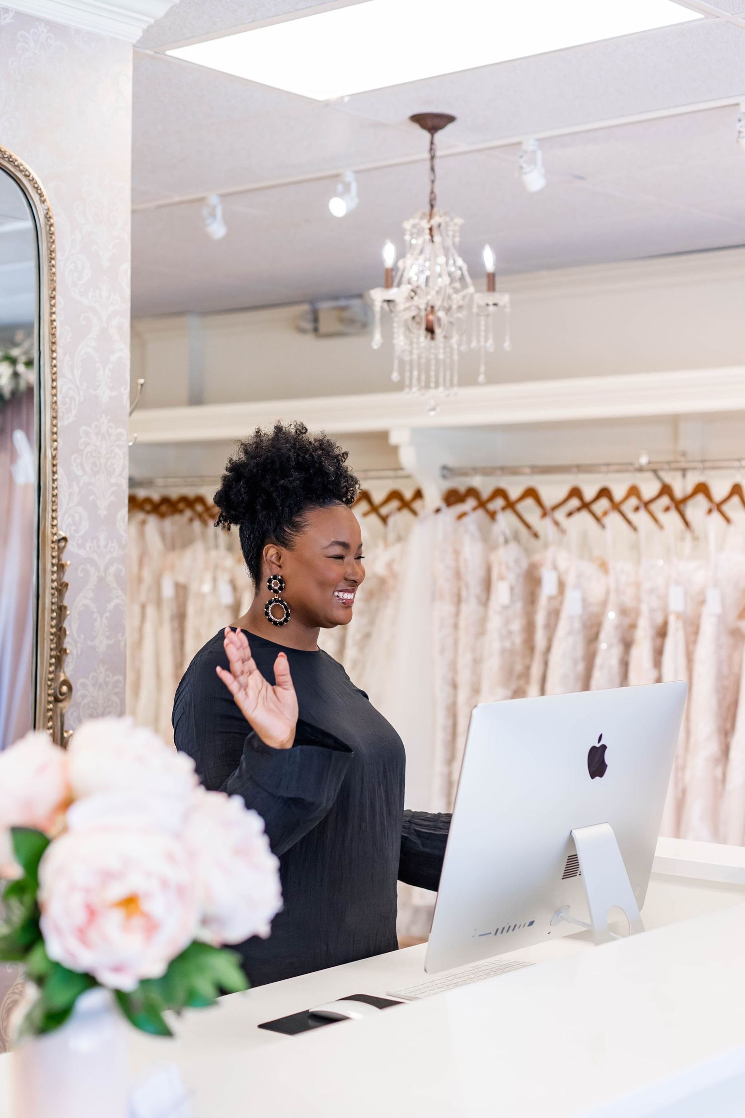 bridal shop worker saying hello to customer