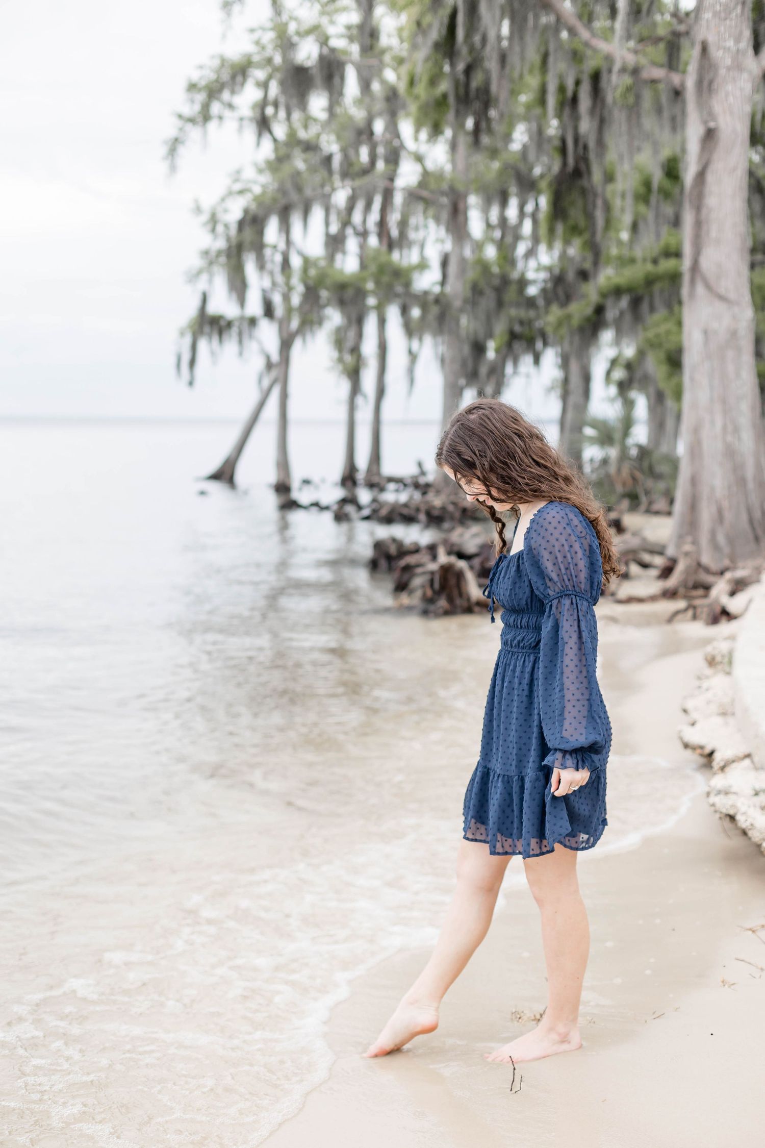 girl dipping toes in the water/sand