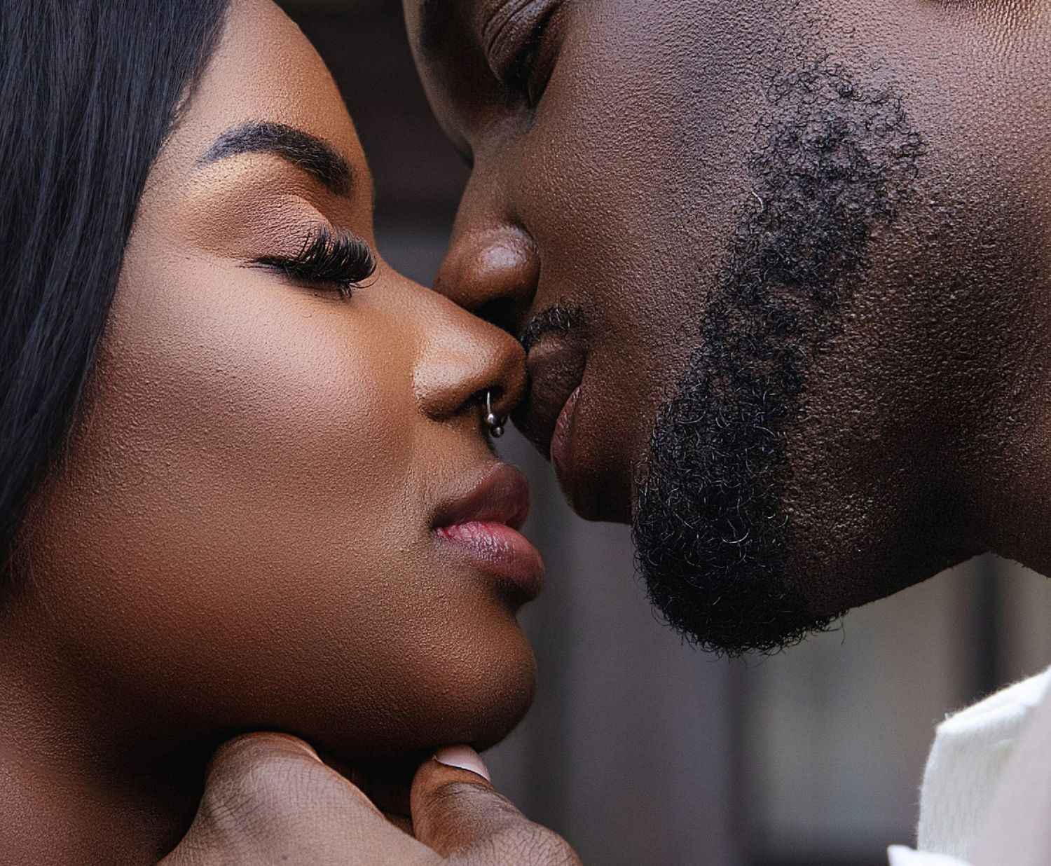 Close-up of a couple sharing a tender kiss in a romantic portrait.