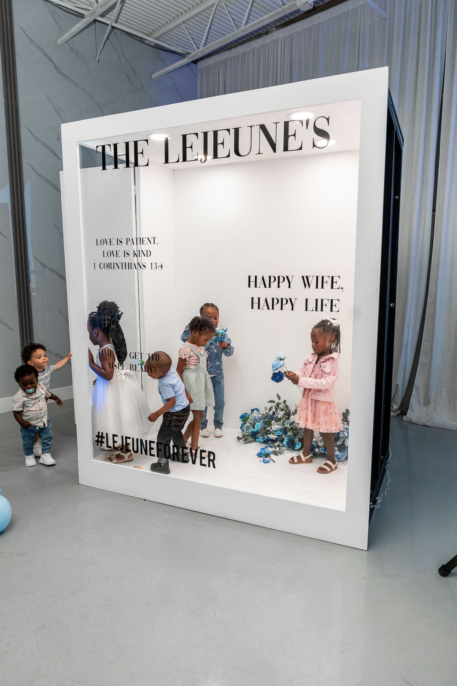 Group of young children explore The Lejeune's oversized custom wedding photo booth frame installation.