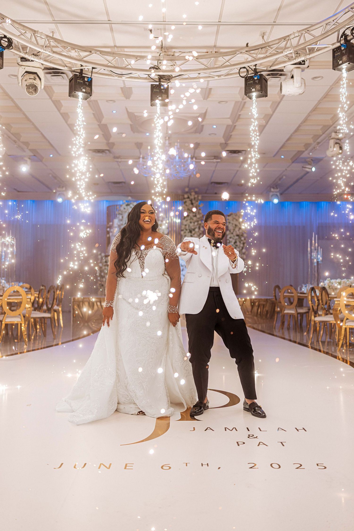 Jamilah and Pat share their first dance on a white dance floor with sparkling light curtains at their June 6th, 2025 wedding.
