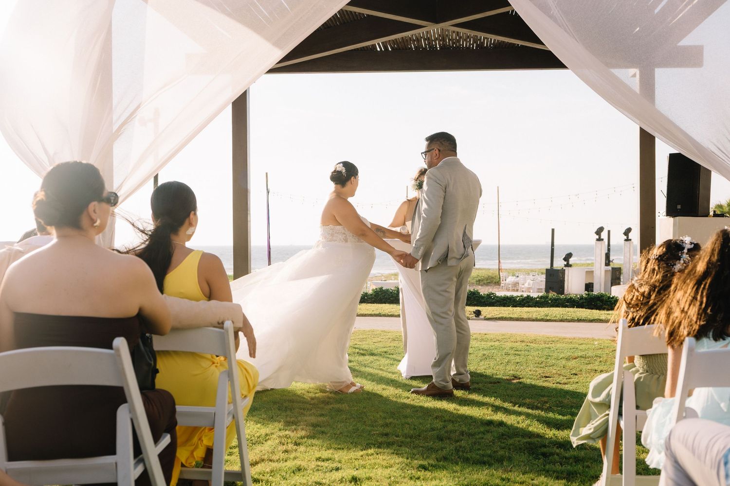 Ceremonia de boda frente al mar en el Hotel Dreams Estrella del Mar Mazatlán, novios tomados de la mano durante el intercambio de votos