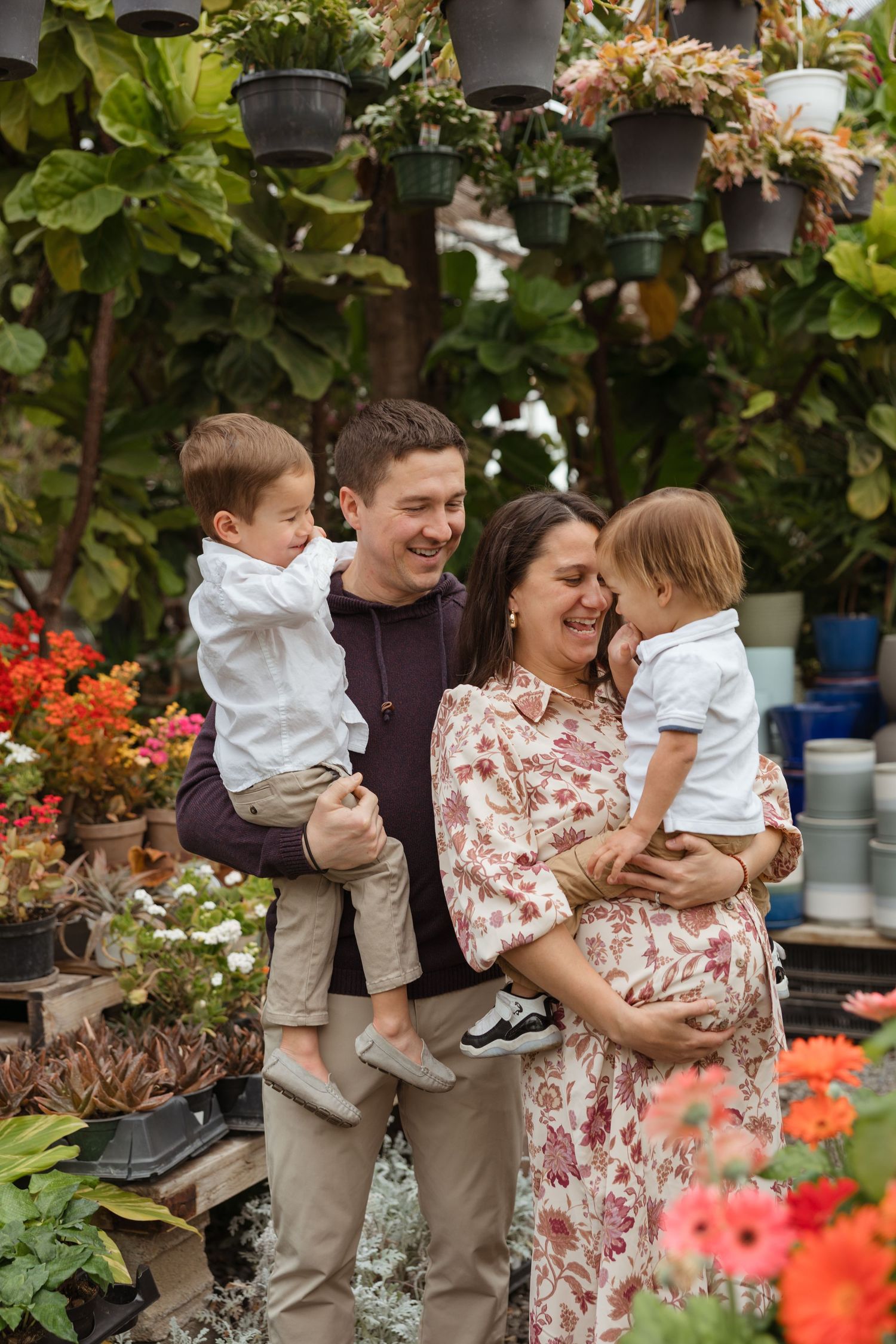 Happy family with two toddlers smiling during their maternity photoshoot at Bountiful Gardens in Ewing, NJ.