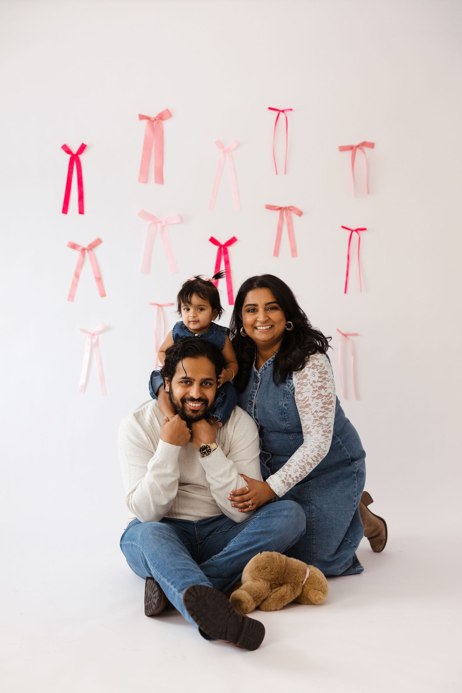 Family of three smiling during a studio milestone session in Cherry Hill, NJ.