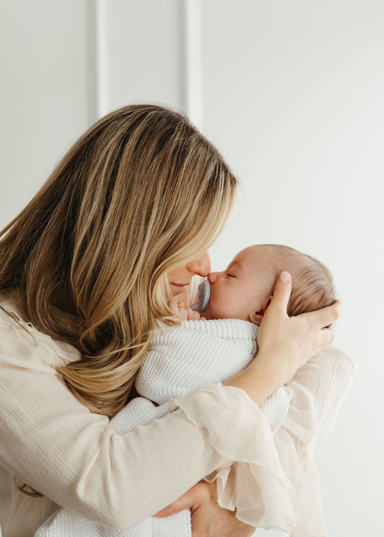Mother holding her newborn during a calm, baby-led lifestyle newborn session in South Jersey.