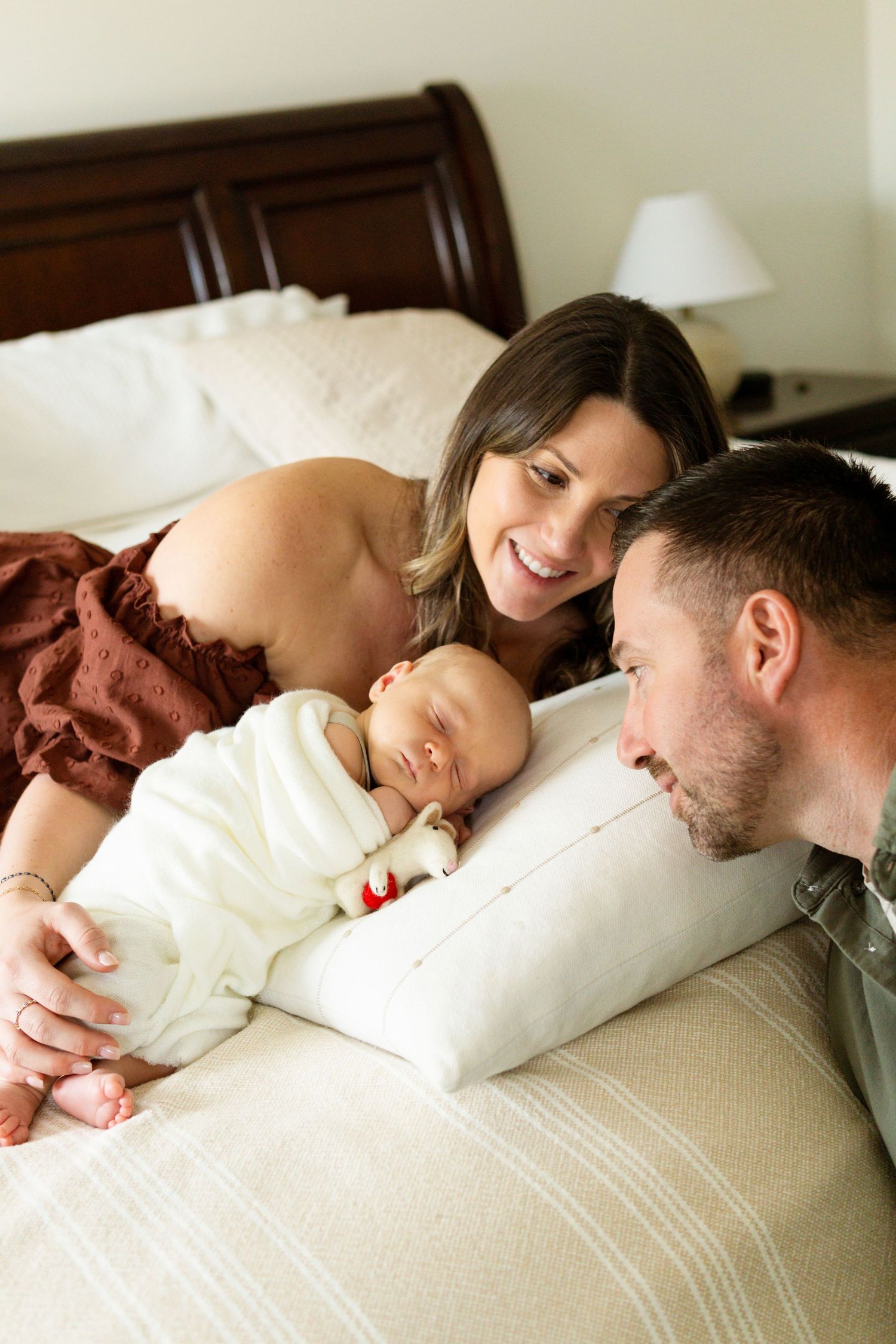 Parents looking at their newborn fondly during an in-home newborn session in South Jersey.