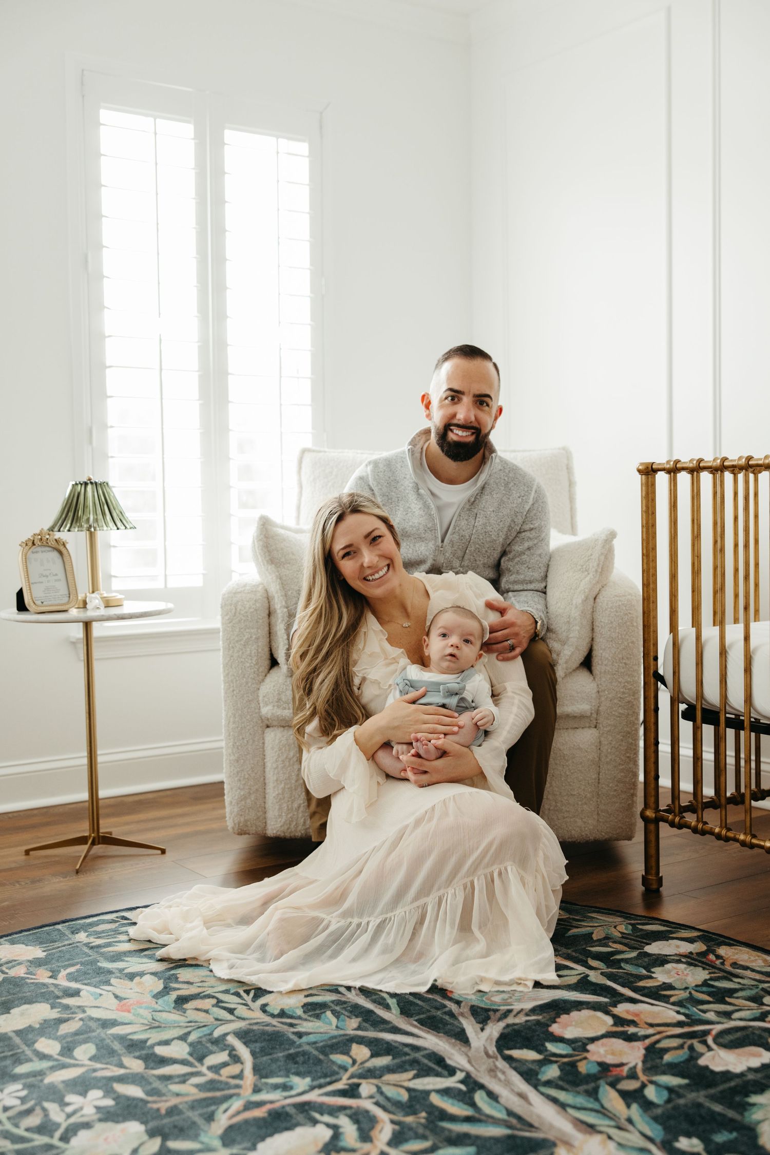 Family lounging together on a beige couch with a blue and white patterned rug.