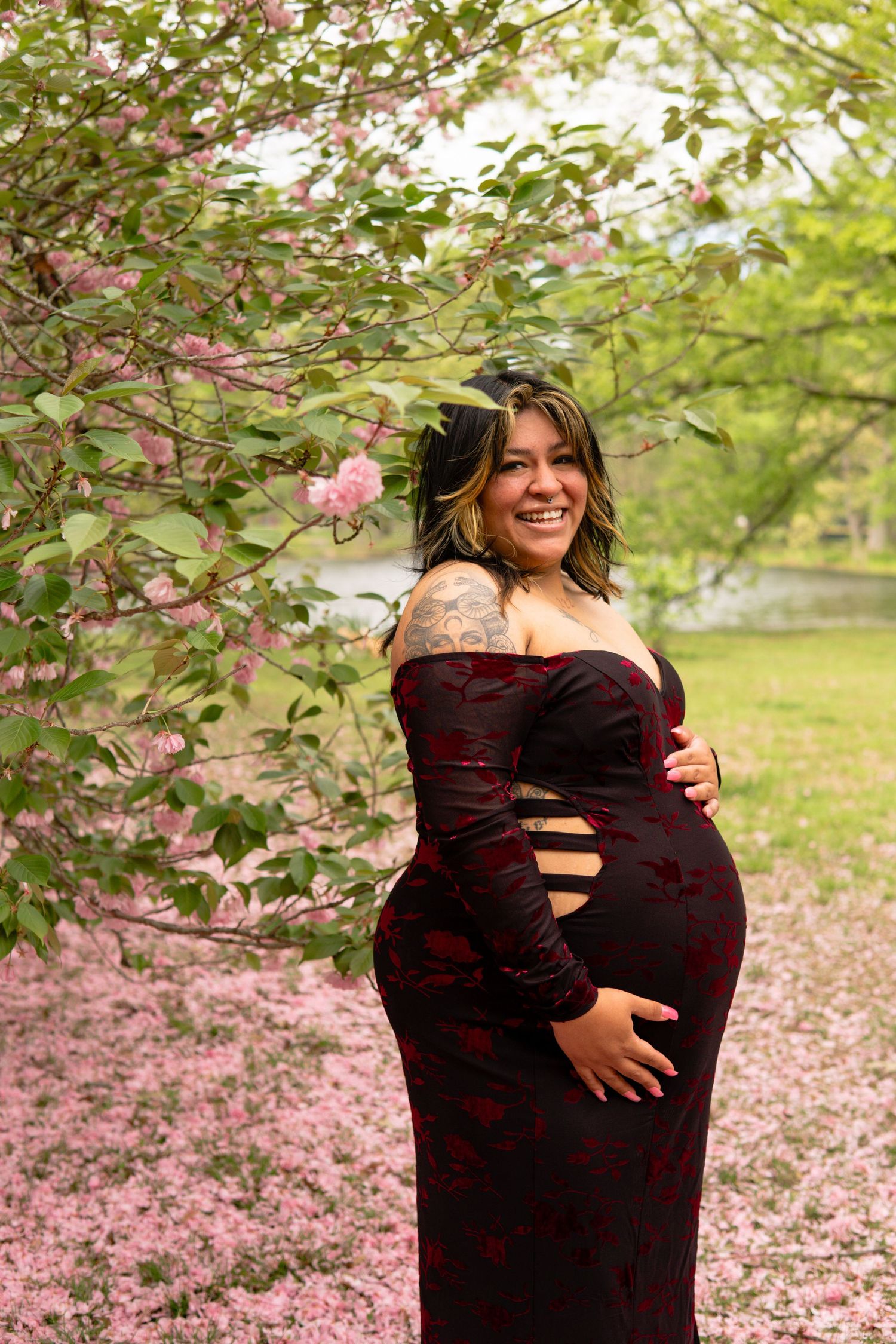 Expectant mother standing beneath cherry blossoms at Knight Park in Collingswood, NJ during a spring maternity session.