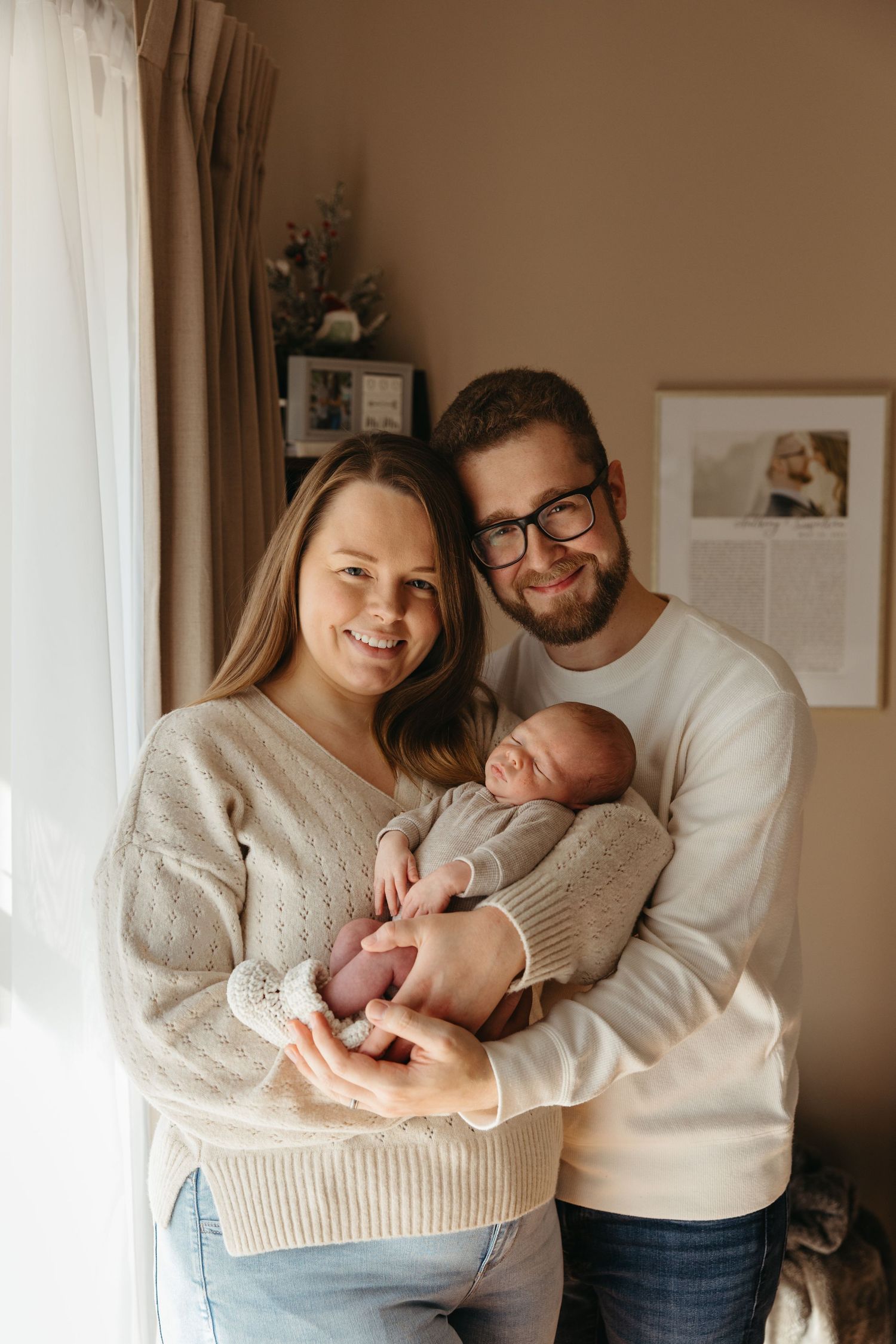 Family of three smiling during an in-home newborn session in Cherry Hill, NJ photographed by a South Jersey newborn photographer.