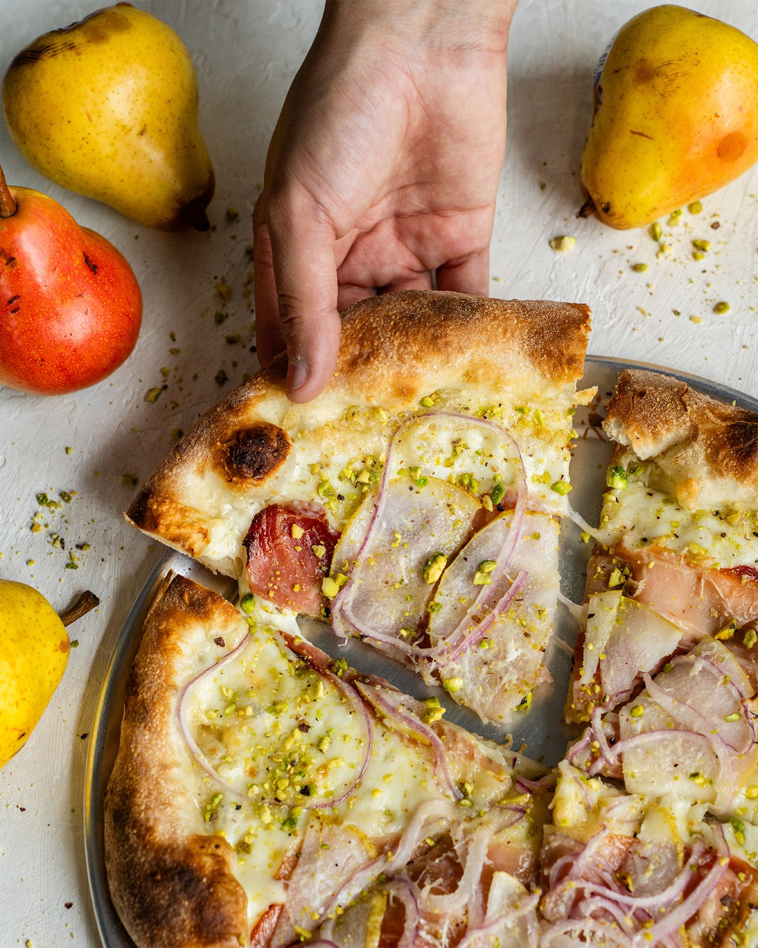 Cheesy pear pizza photographed using natural window light.