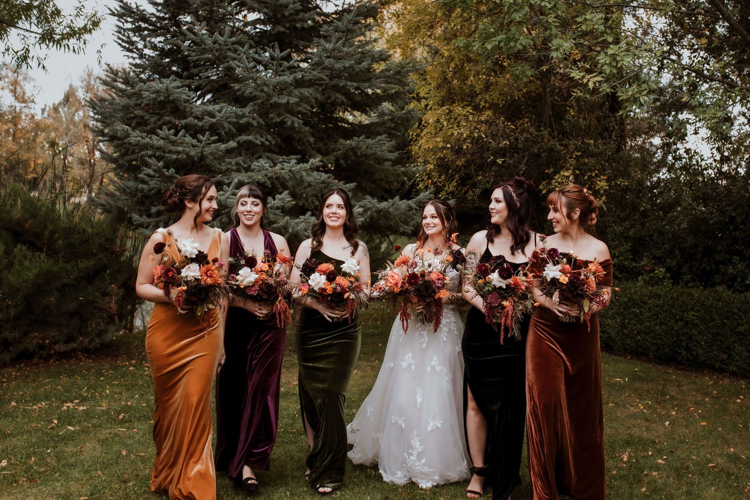 Wedding party poses together outdoors in earth-toned attire against an autumn backdrop. by safford arizona photographer