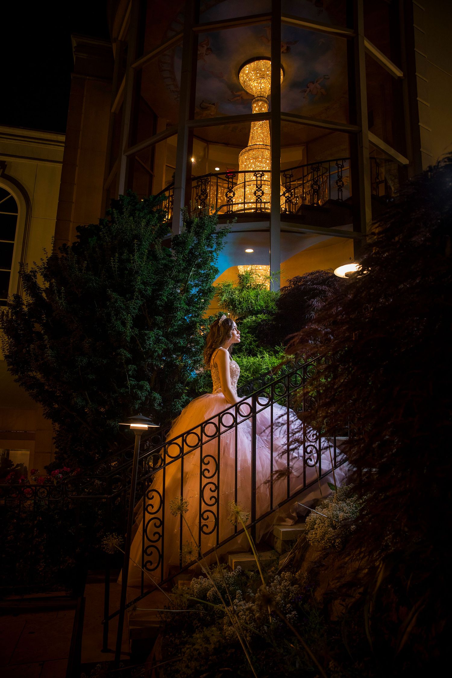 A series of nighttime photos showing a white dress illuminated on outdoor stairs with ornate railings and garden foliage.