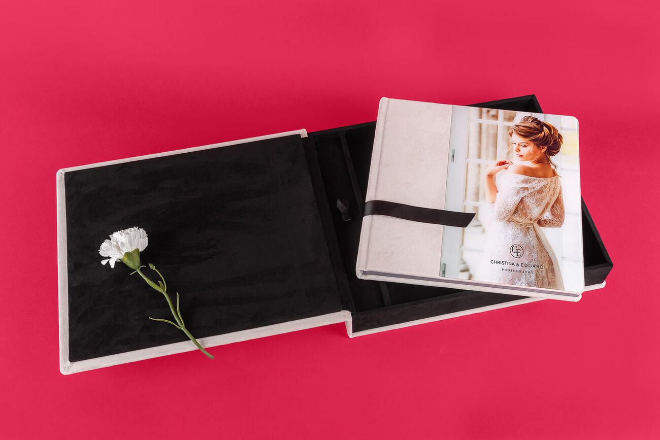 Elegant white wedding invitations and envelopes arranged with floral elements on vibrant pink background.