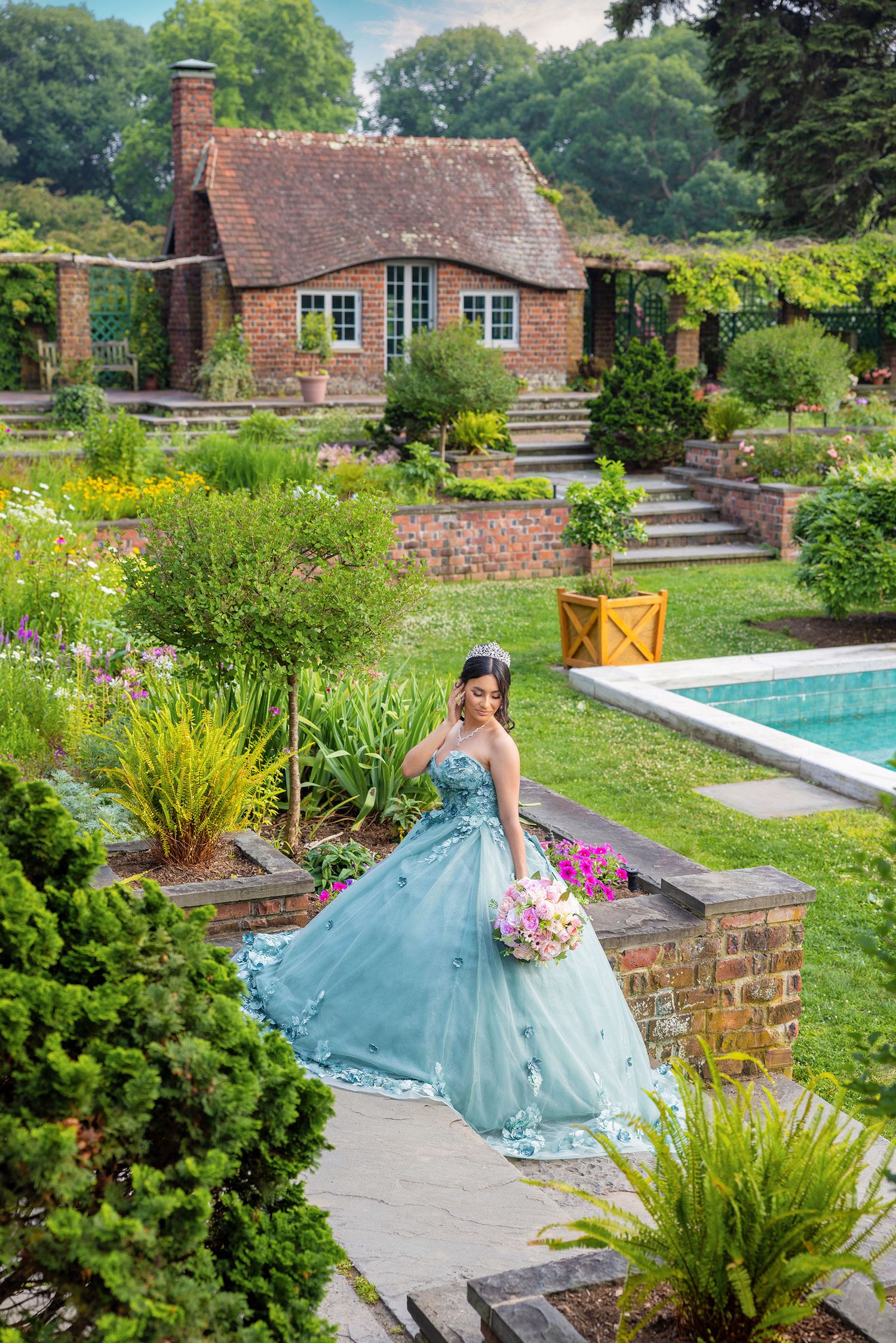 A stunning garden setting with brick pathways, lush greenery, and a swimming pool surrounded by flowering plants and landscaping.