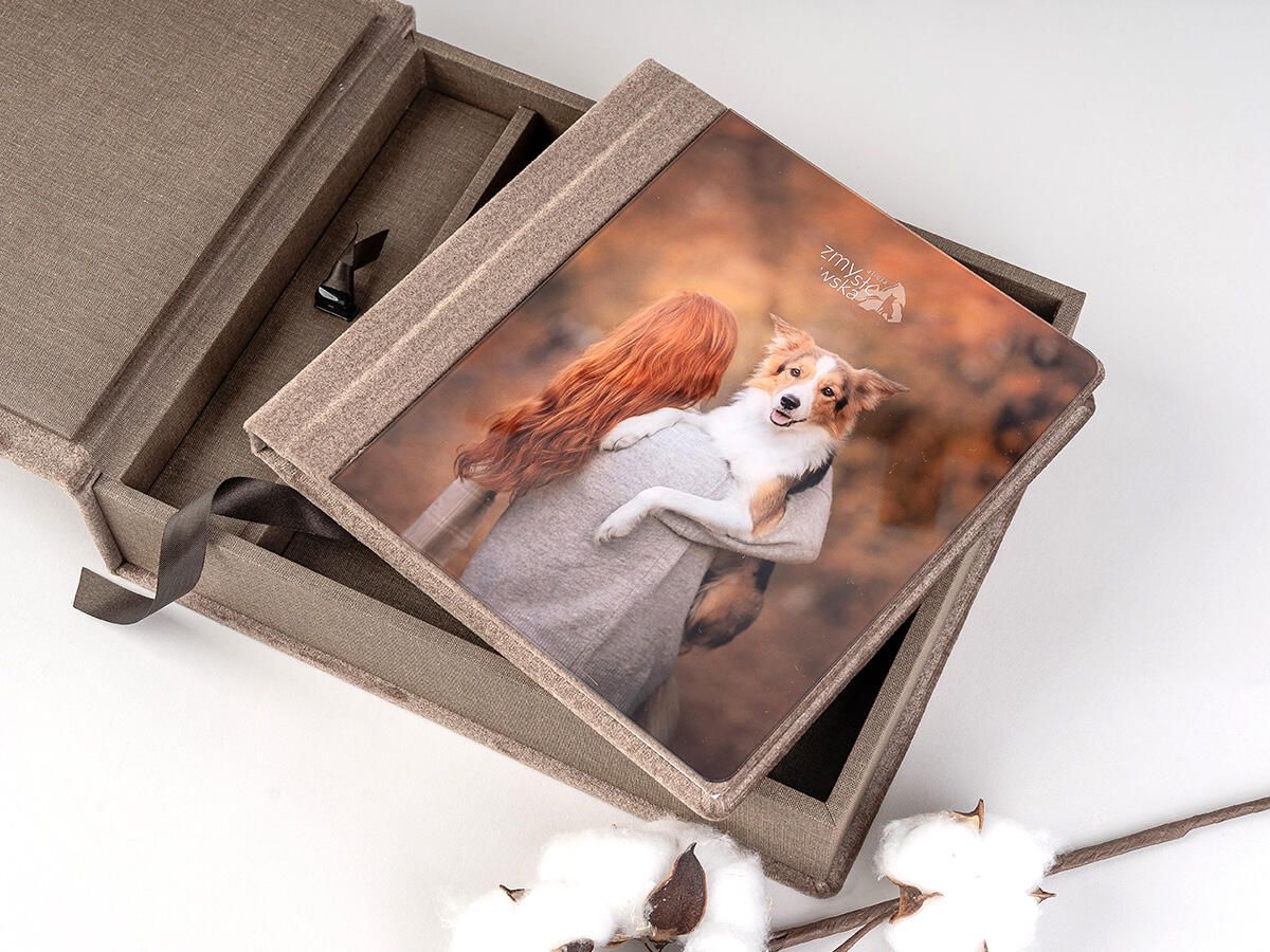 A professional photo print of a white dog displayed in an elegant gray wooden box with cotton decorative elements.