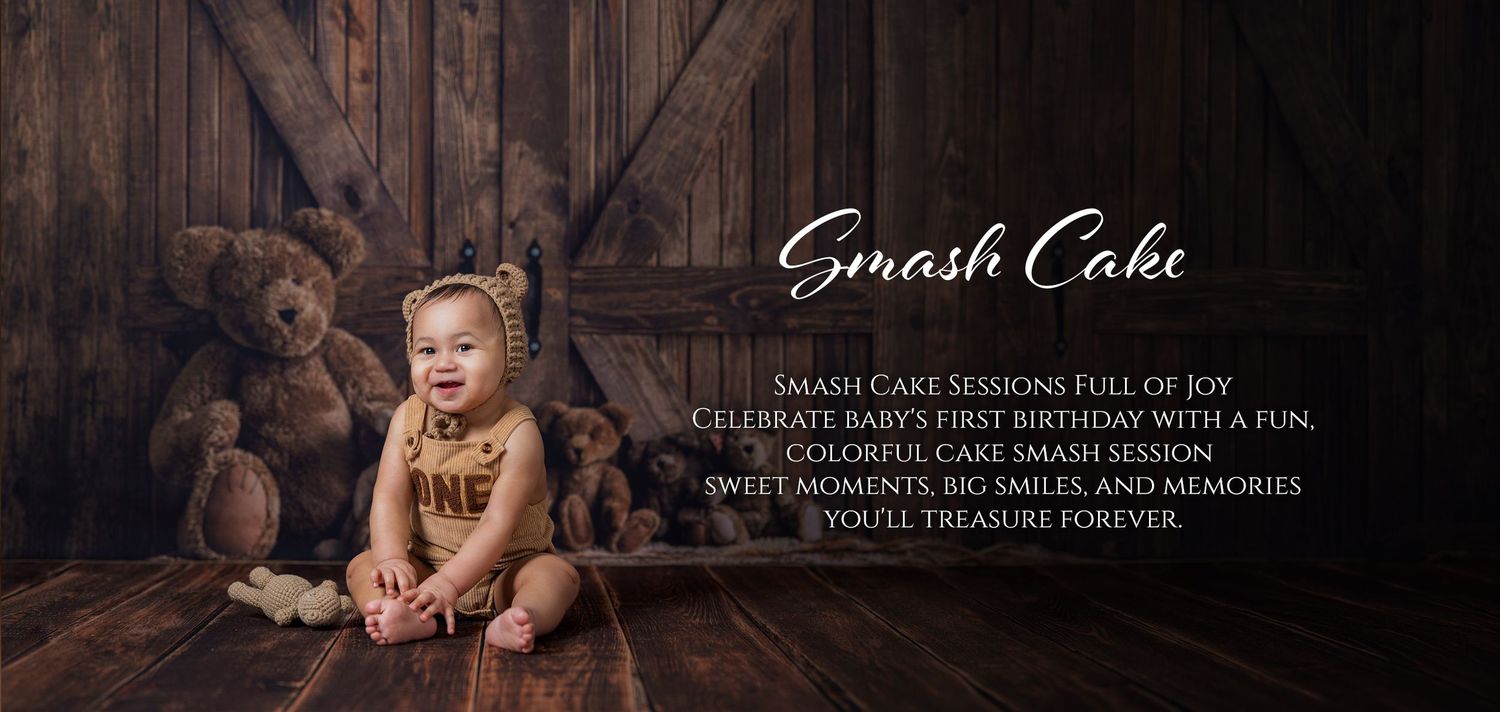 Baby in a onesie smiling during a colorful smash cake photography session with teddy bears on a rustic backdrop.