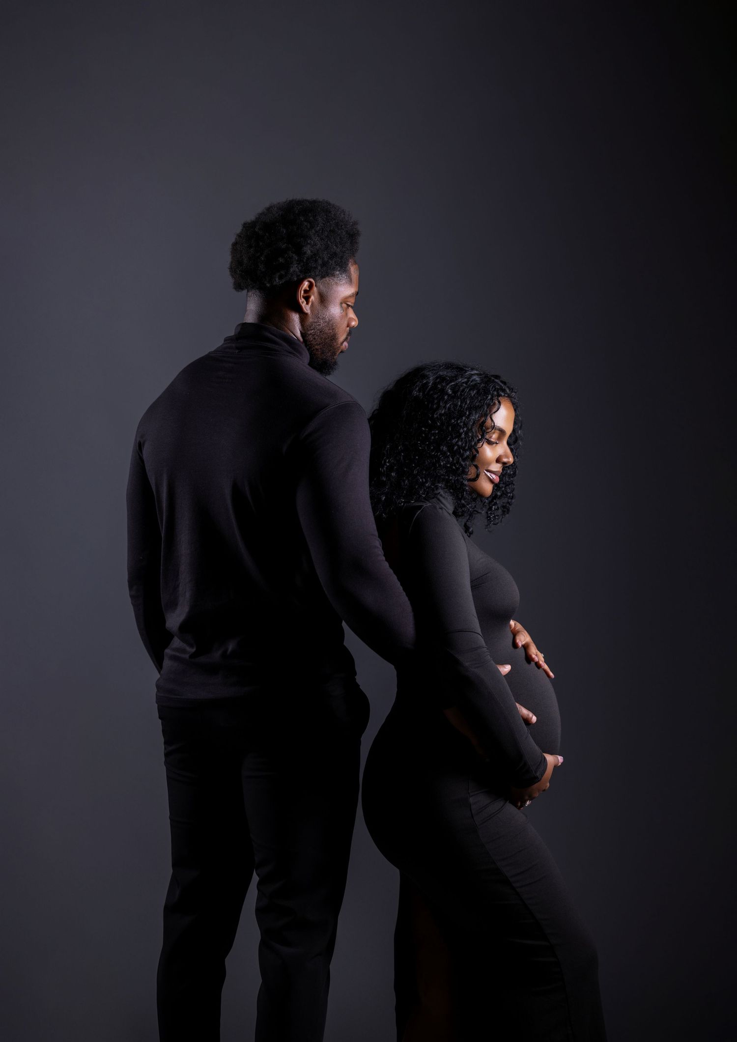 A series of four silhouetted figures in black clothing pose against a dark background in dramatic poses.