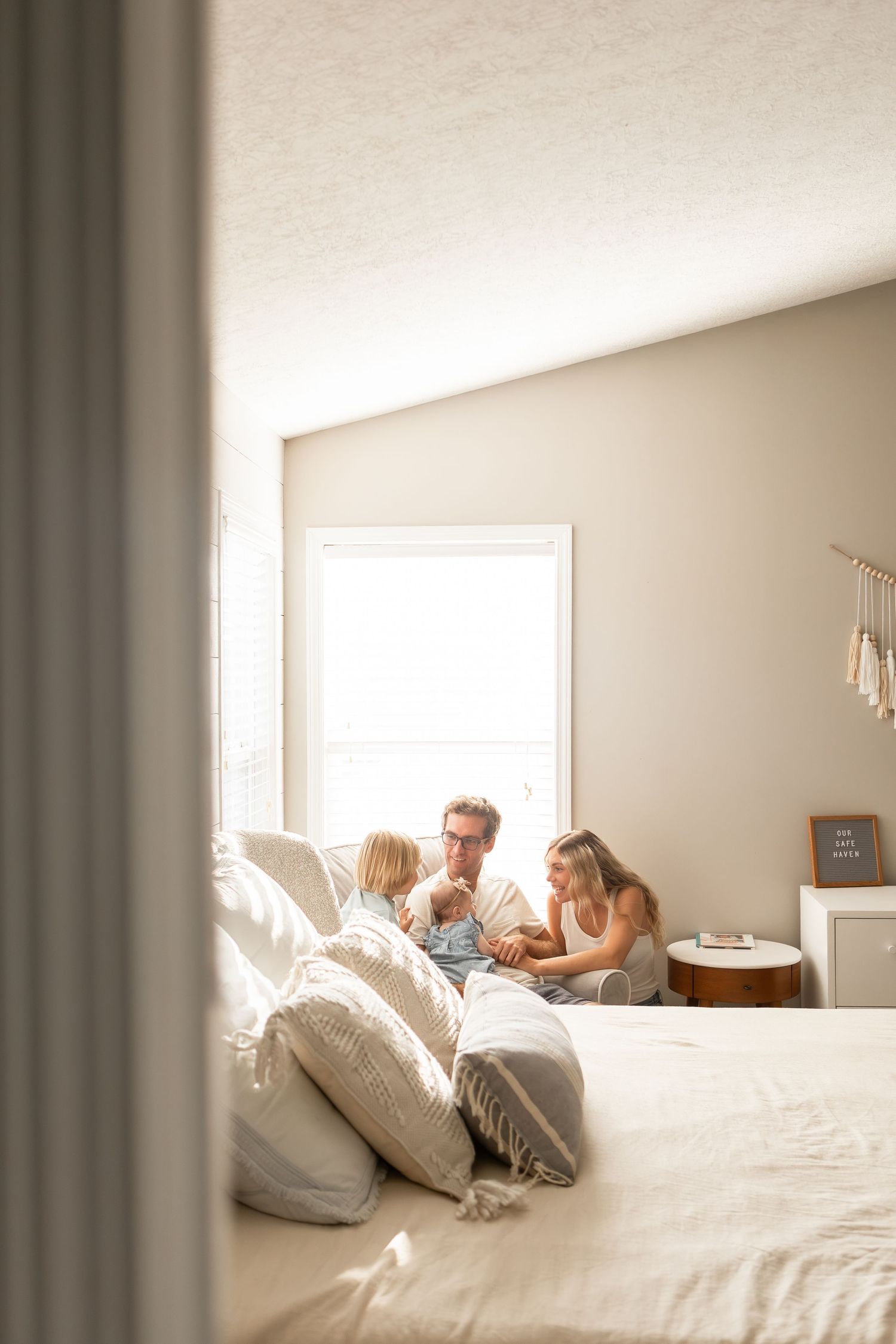 Family of four sitting together in bedroom in Columbus Ohio