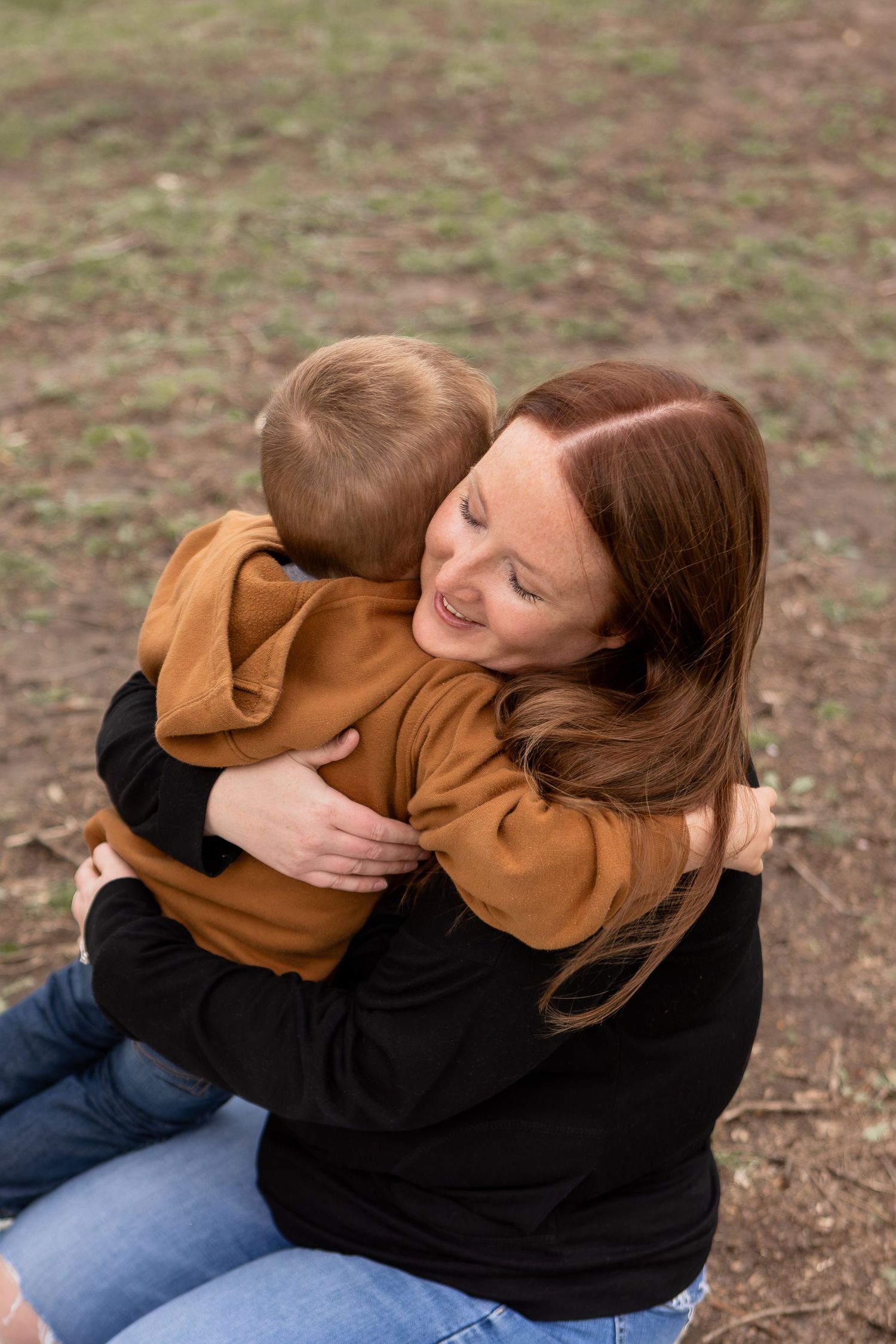Mom sitting on knees embracing son in Columbus Ohio