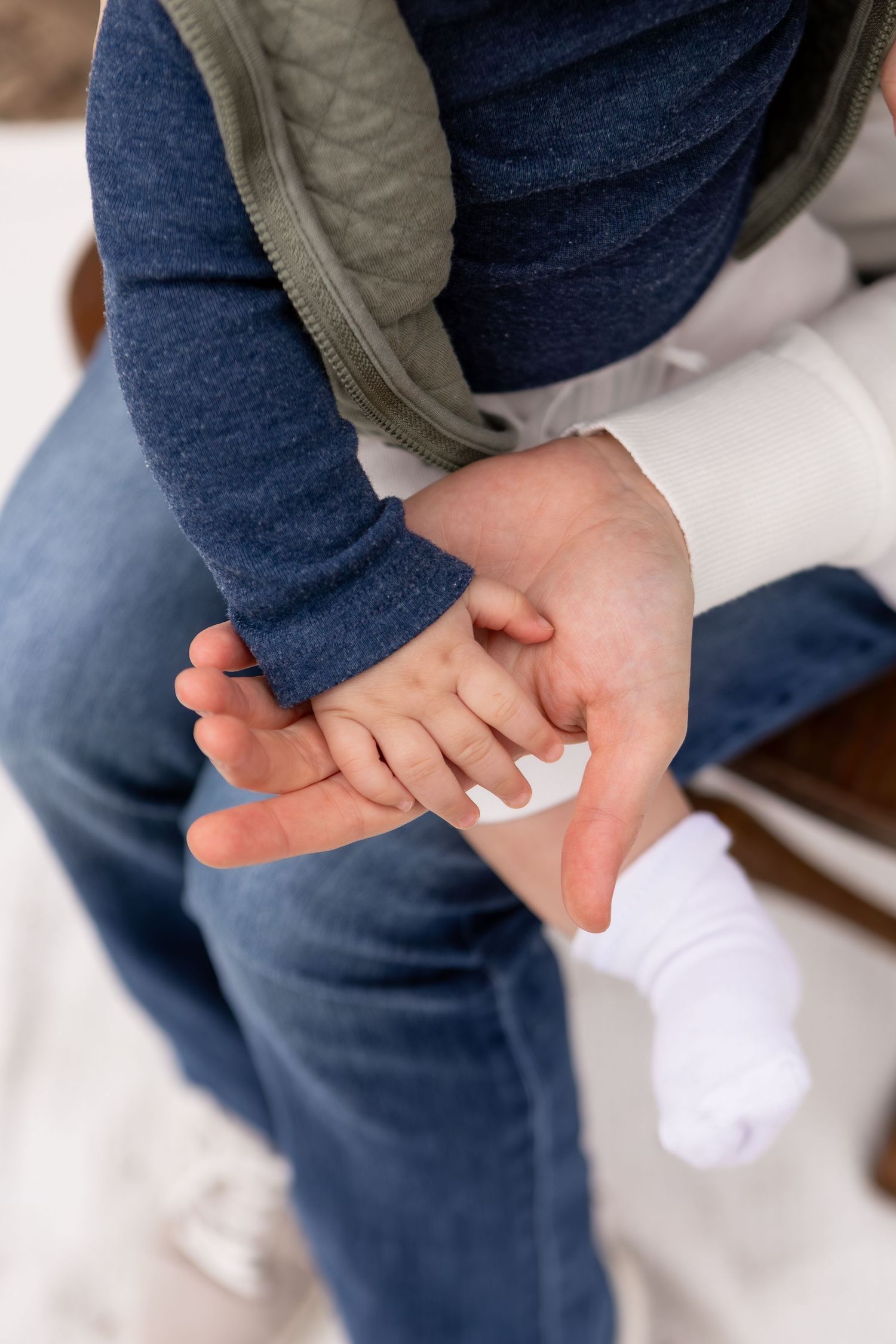 Mom holding baby's hand wearing blue and green in Columbus Ohio
