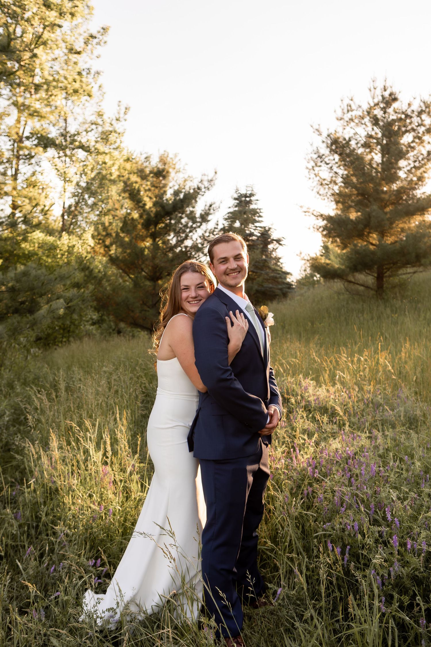 Bride and groom hugging in field on wedding day in Columbus Ohio