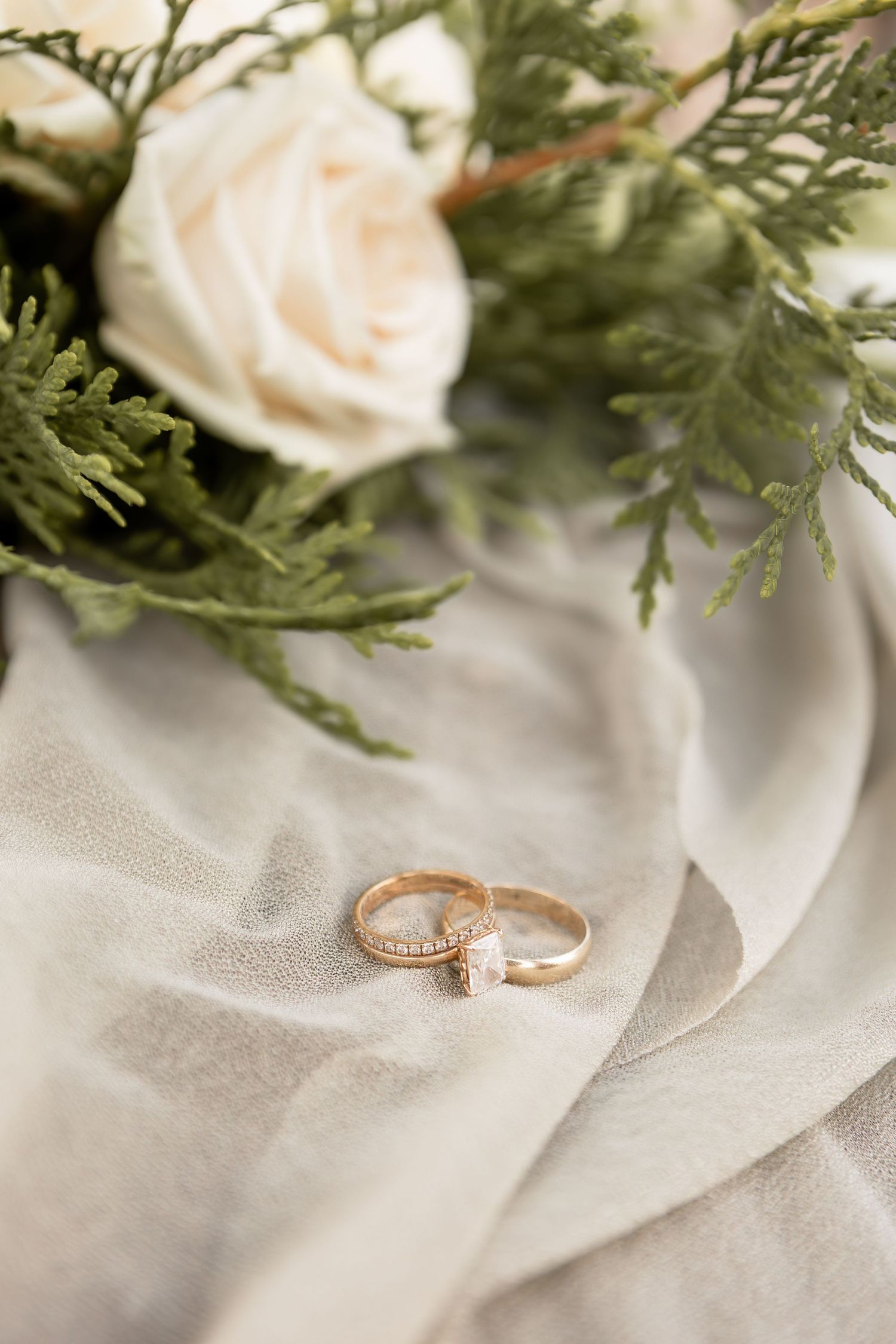 Wedding rings on green table runner with white roses at wedding in Columbus Ohio