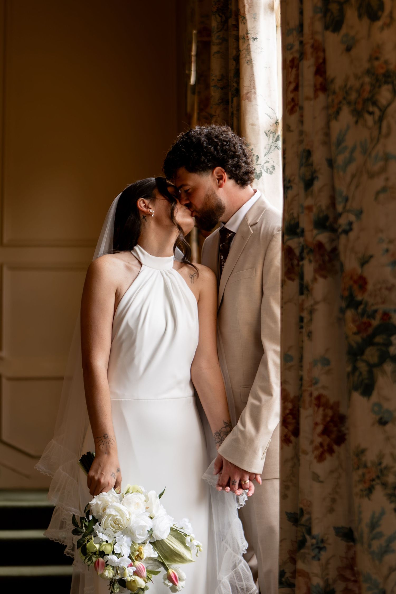 Bride and groom kissing standing in front of window in mansion in Mansfield Ohio