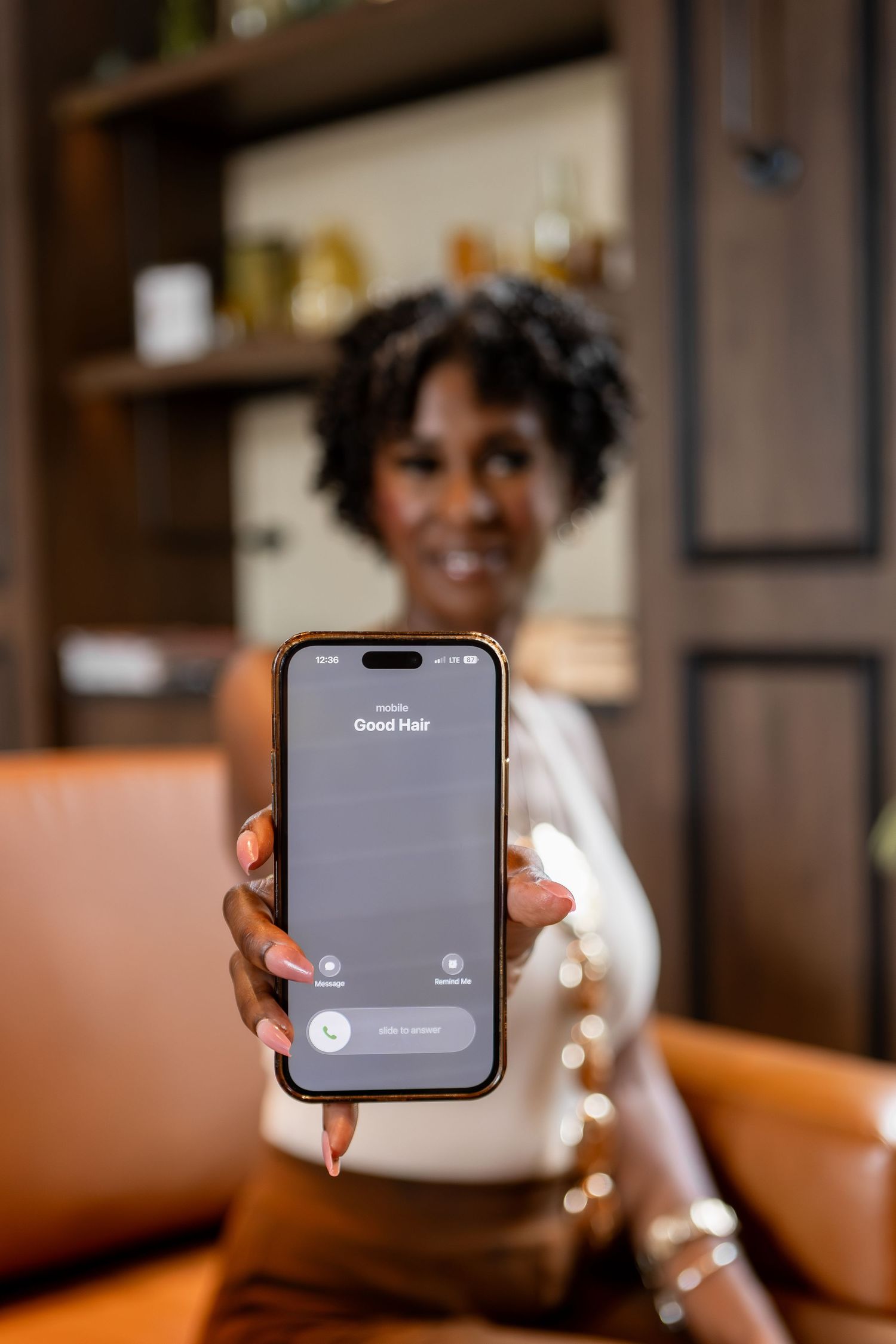 Woman holding out phone saying 