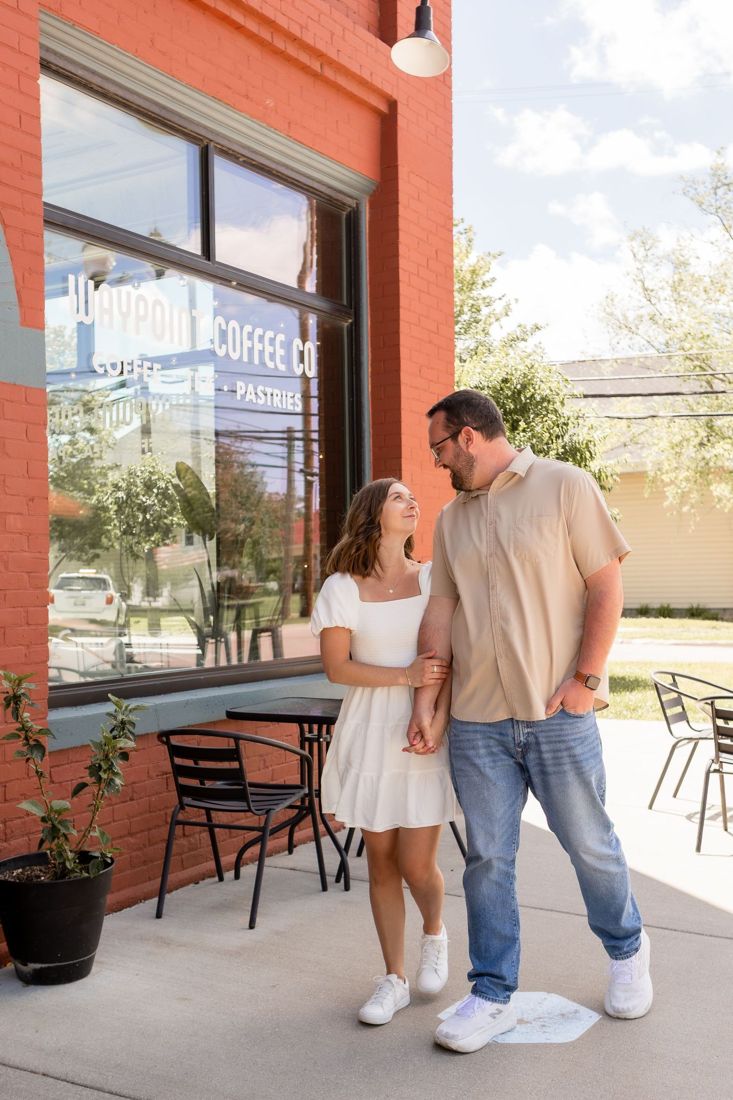 Couple in neutral outfits walking outside coffee shop on date in Columbus Ohio