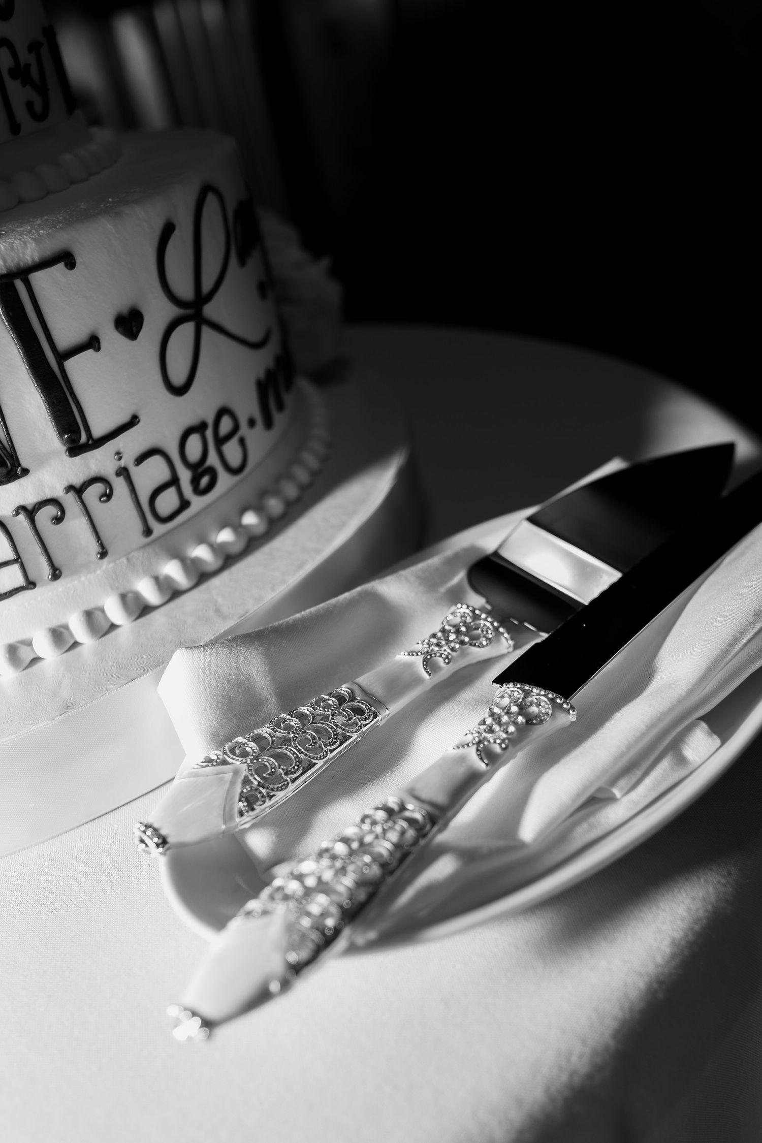 Black and white details of wedding cake cutting and serving knives beside wedding cake in Cleveland Ohio