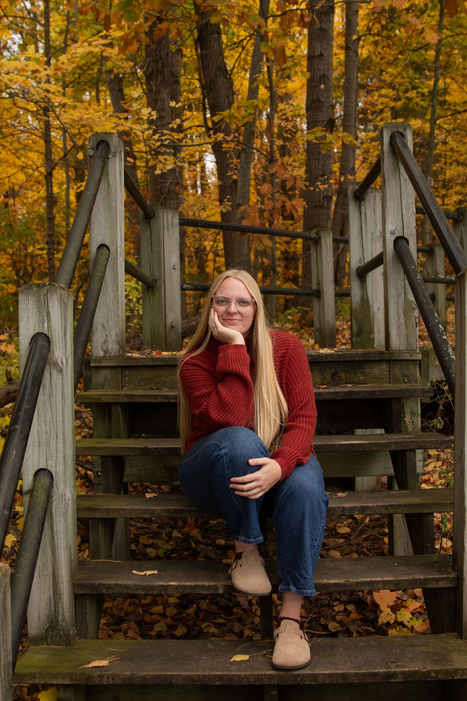 Woman sitting on steps in fall forest in Columbus Ohio