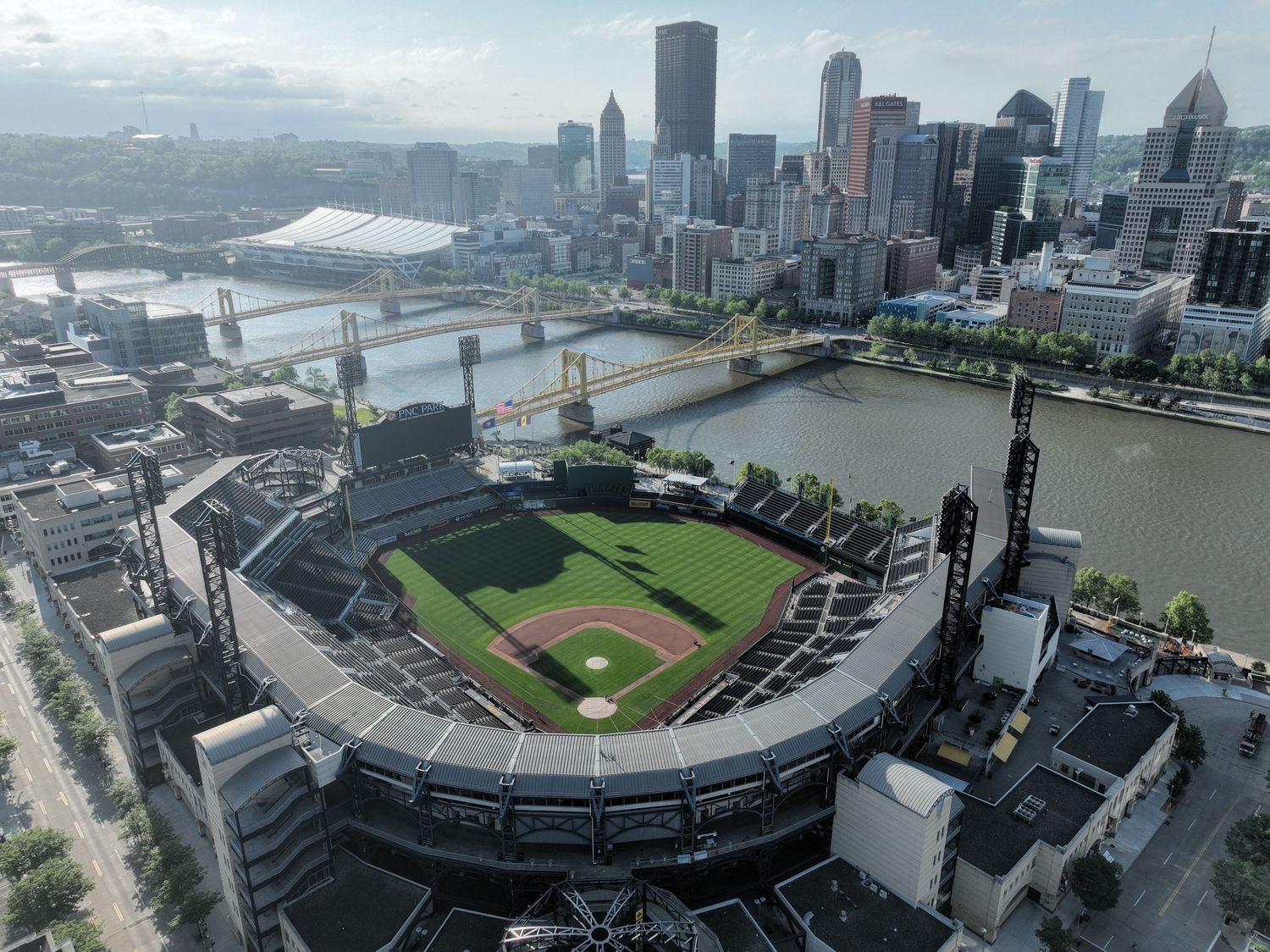Aerial view of PNC Park baseball stadium in Pittsburgh, PA, with the city skyline and rivers in the background.